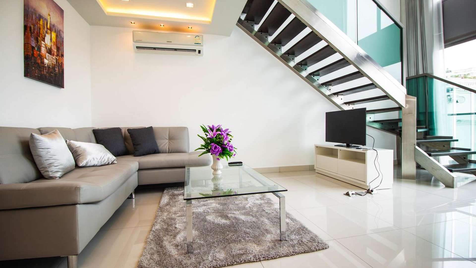 Modern living room in Wong Amat Tower apartment, Pattaya, featuring sleek decor and staircase