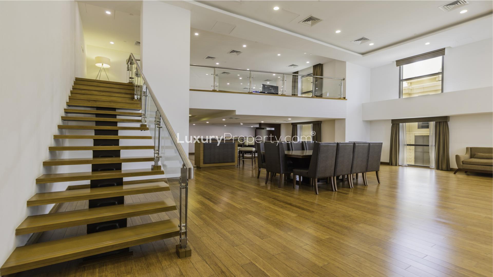 Living room in JBR duplex loft, modern decor, large sofa, and wall-mounted TV