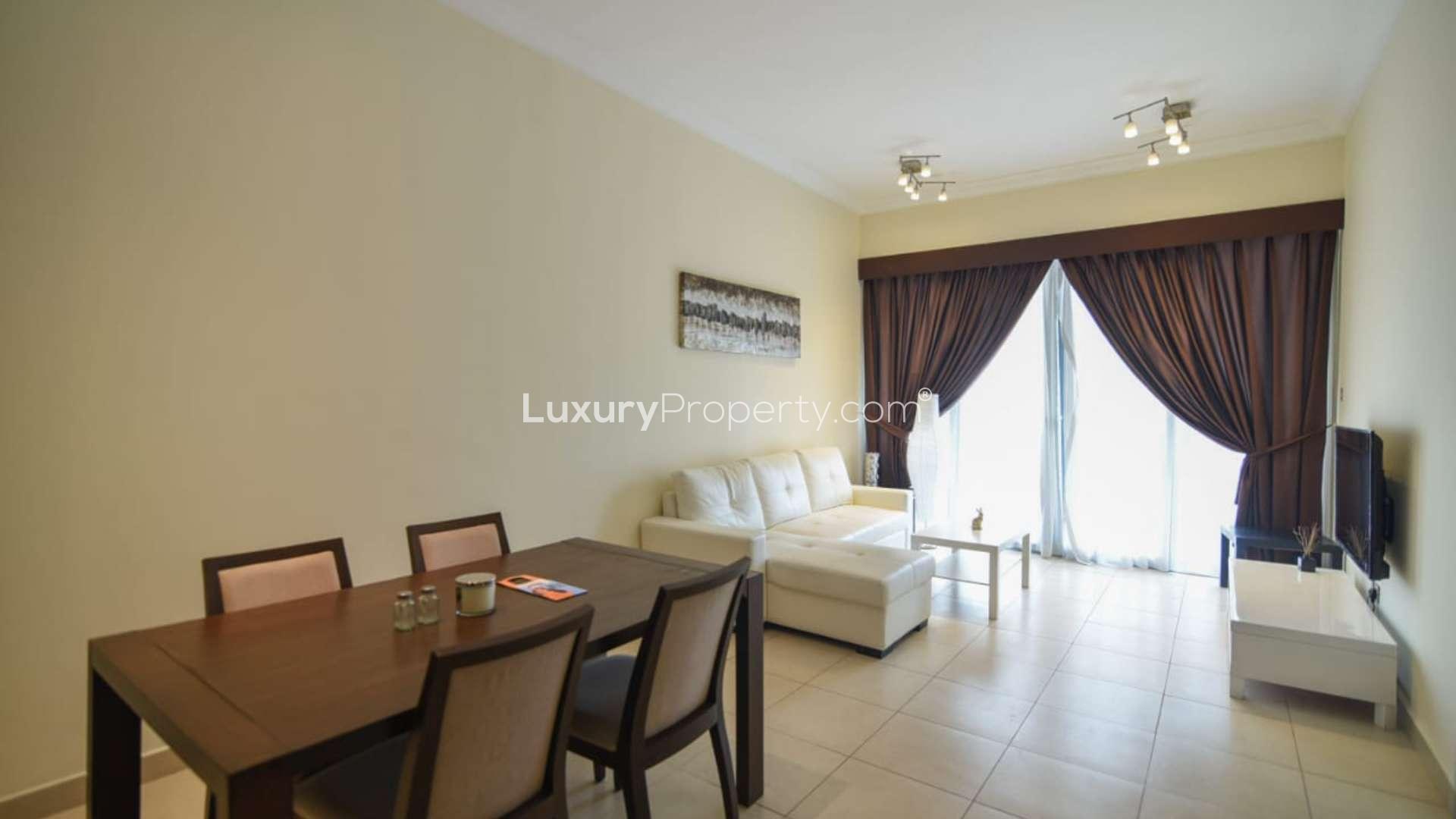 Alt text: "Downtown Dubai apartment view with large terrace and city skyline, Mohammad Bin Rashid Boulevard.",Fully furnished living room in Downtown Dubai apartment with dining area and large windows