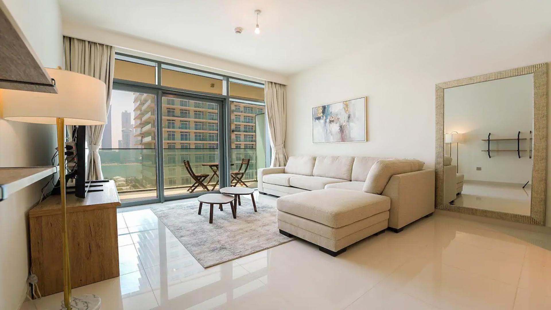 "Modern apartment building in Emaar Beachfront, Dubai Harbour, available for rent.",Brand new furnished living room in Emaar Beachfront apartment, Dubai Harbour, with balcony view