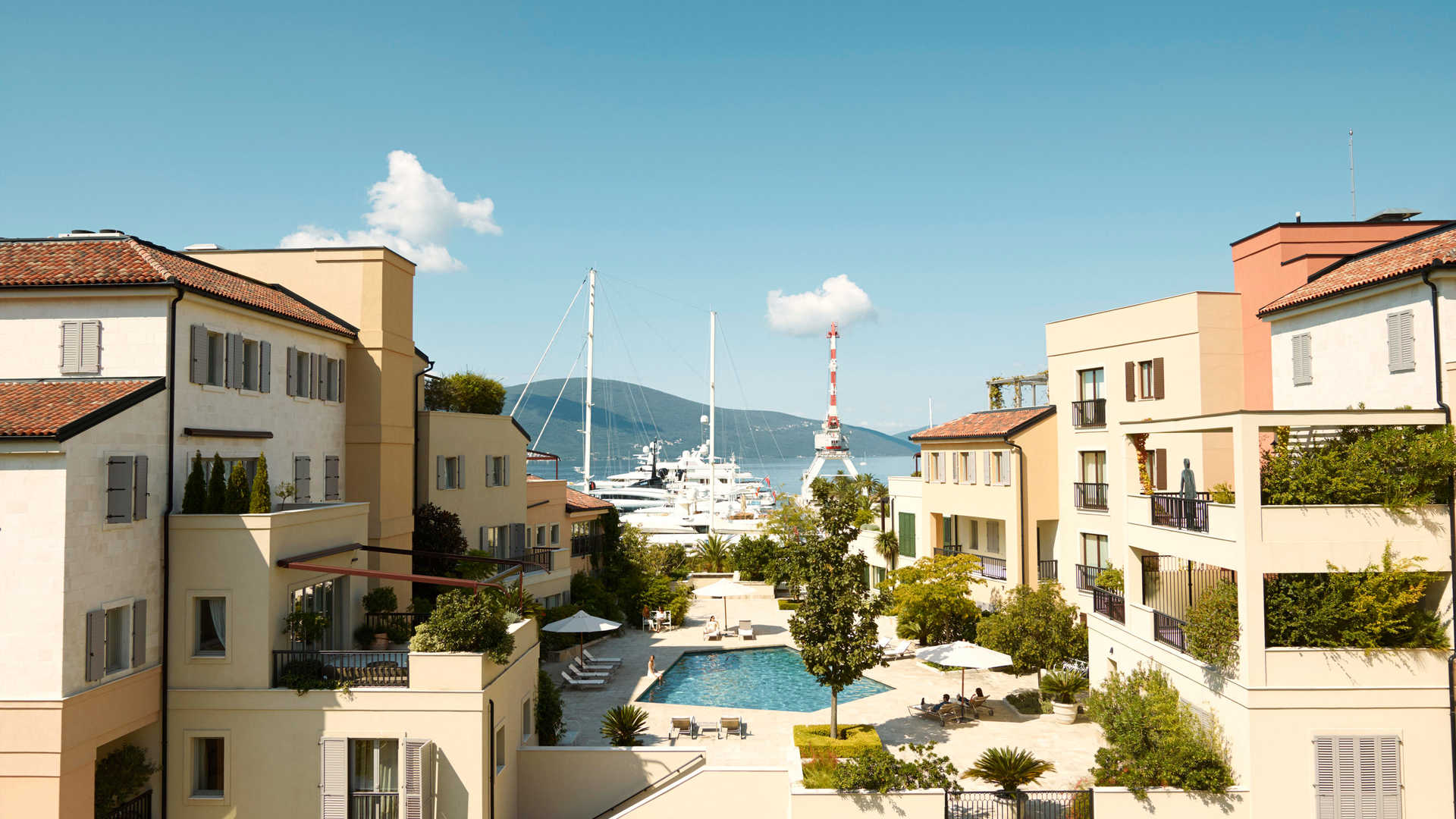 Outdoor pool area at Regent Pool Club Residences Aqua, Porto Montenegro, with sun loungers