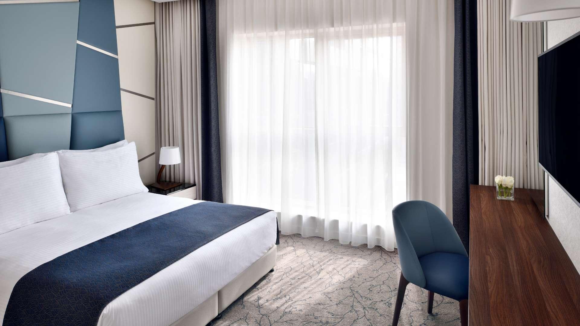 Contemporary serviced apartment living area with city view near Dubai Mall, modern furnishings