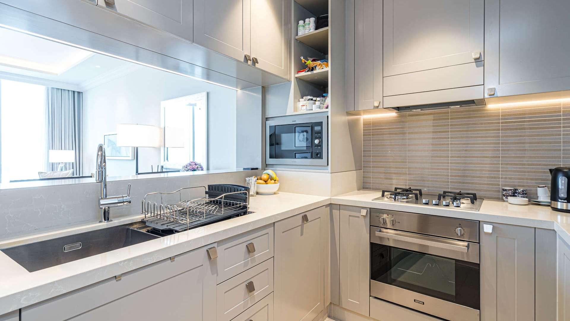 Modern dining area in furnished Downtown Dubai apartment, open kitchen view, The Address Residence