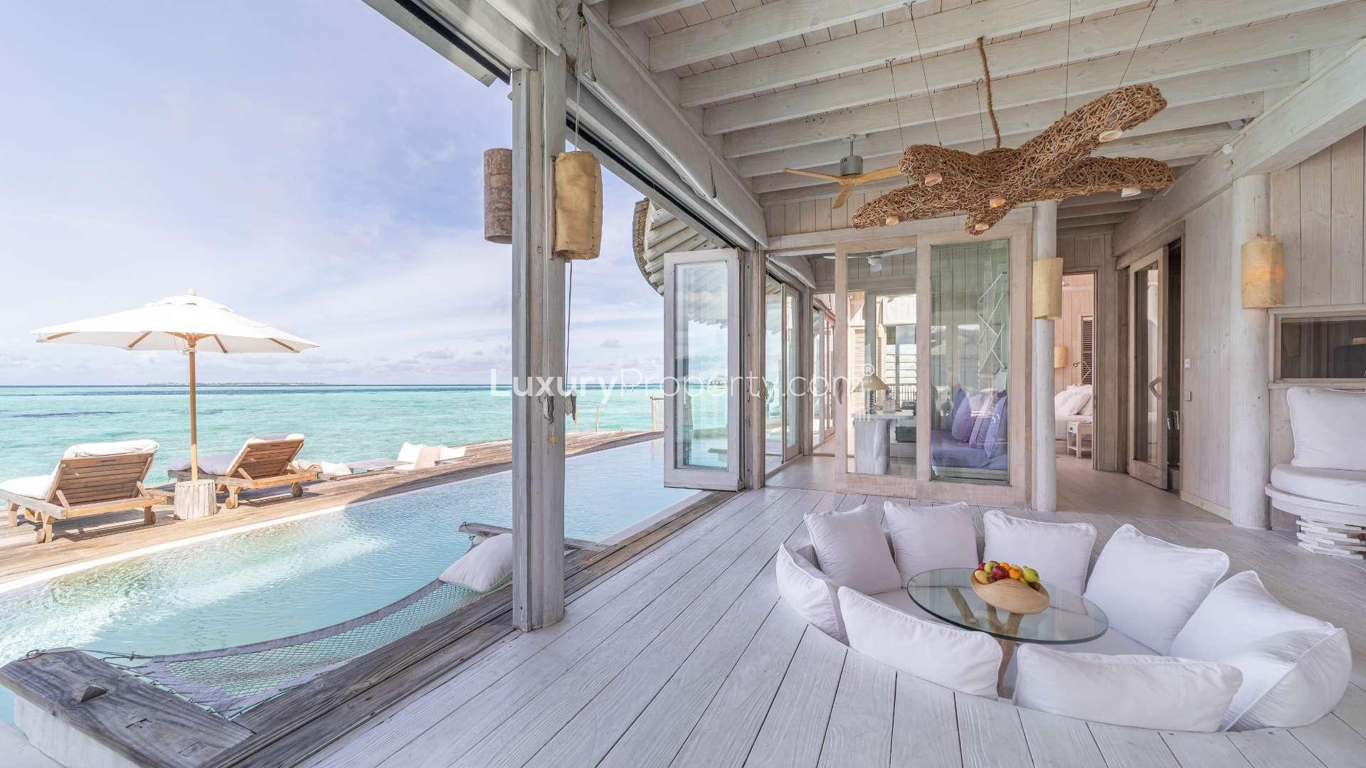 Stunning villa interior with sea view, glass doors, and pool at Soneva Jani, Noonu Atoll
