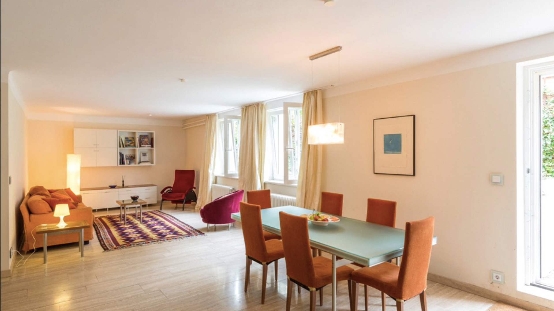 Open-plan living area in 10-bedroom Berlin apartment, featuring modern dining space and cozy seating