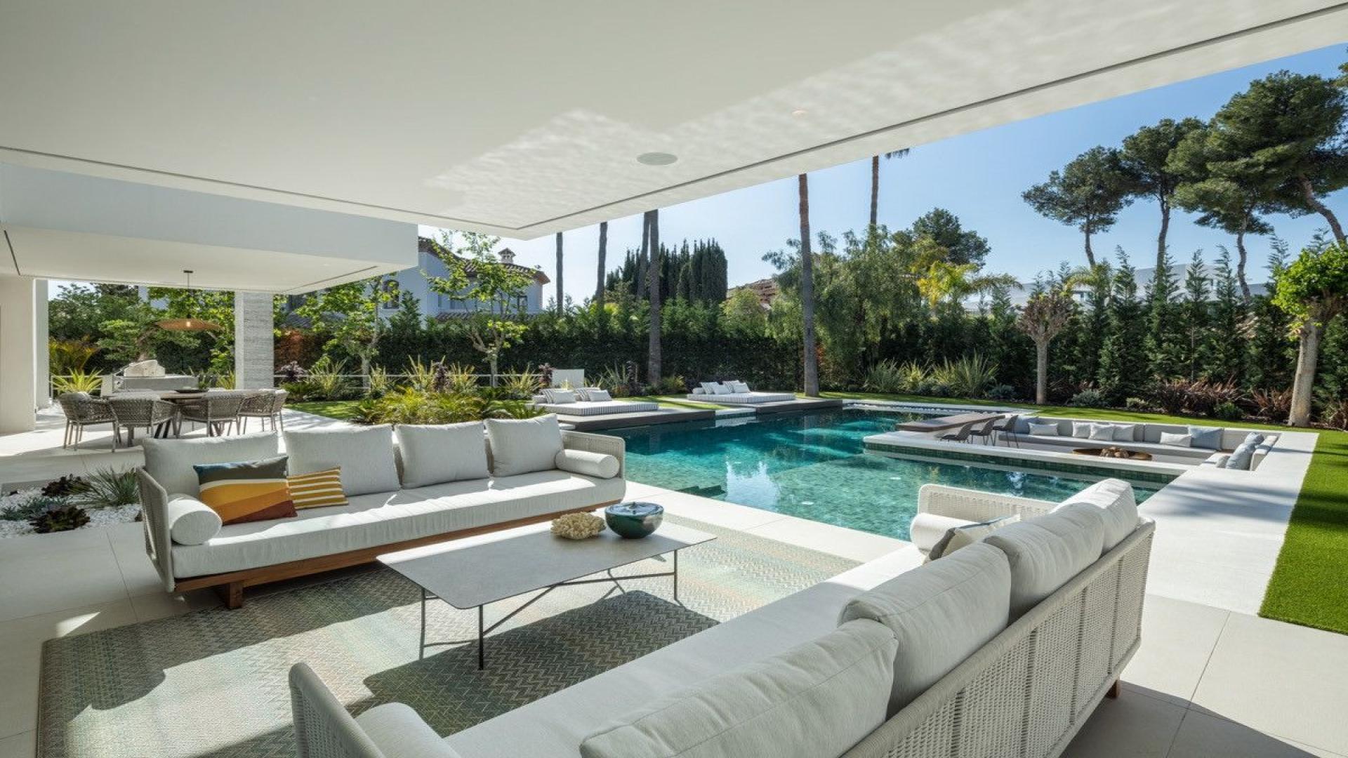 Outdoor seating area overlooking pool in luxury villa, Atalaya Rio Verde, Marbella