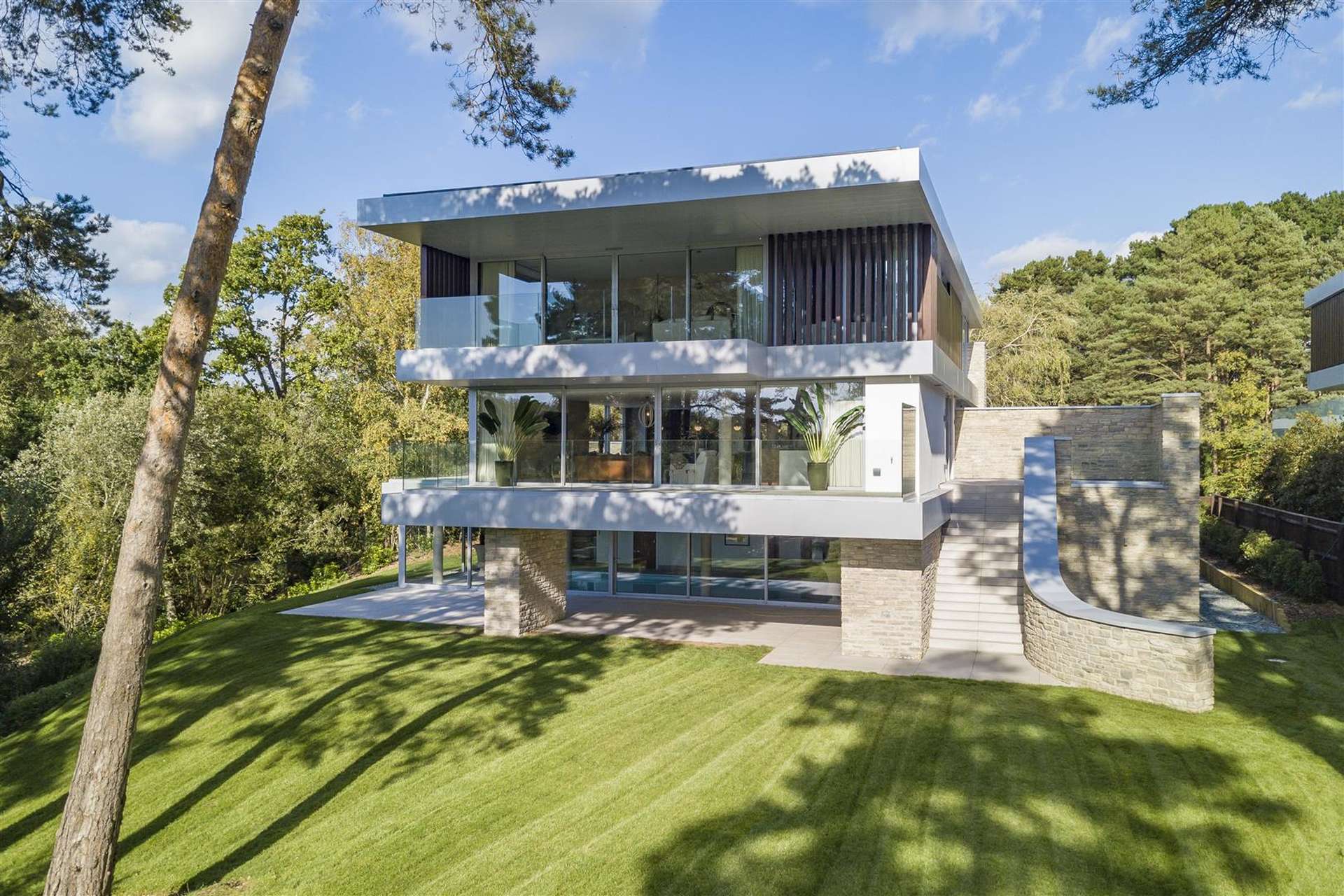 Modern 12-bedroom Luscombe Estate villa exterior with lush lawn, for sale in Sandbanks, Dorset