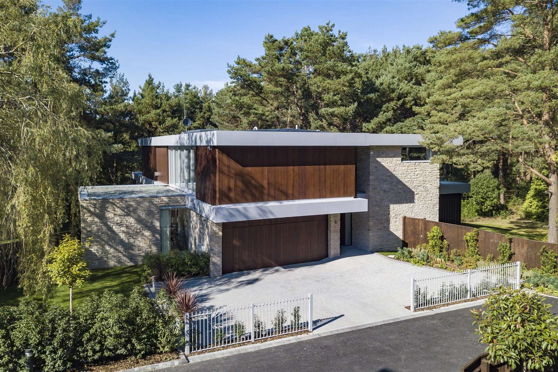 Modern Luscombe Estate villa exterior with lush garden, near Poole Harbour, Sandbanks, Dorset