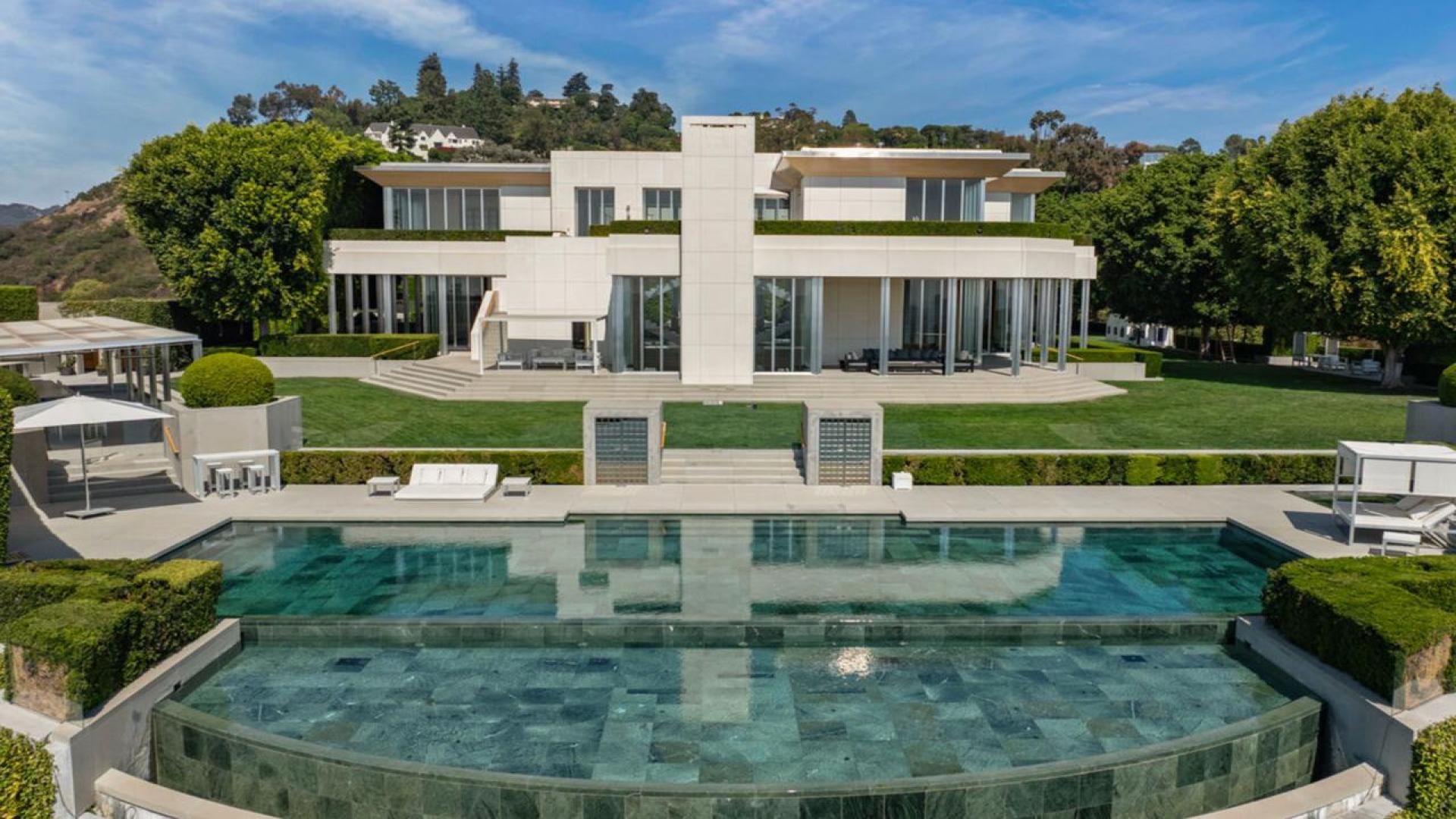 "Luxury Beverly Hills villa patio with panoramic city and ocean views at sunset.",Luxurious Beverly Hills villa with pool, expansive lawn, and modern architecture for sale