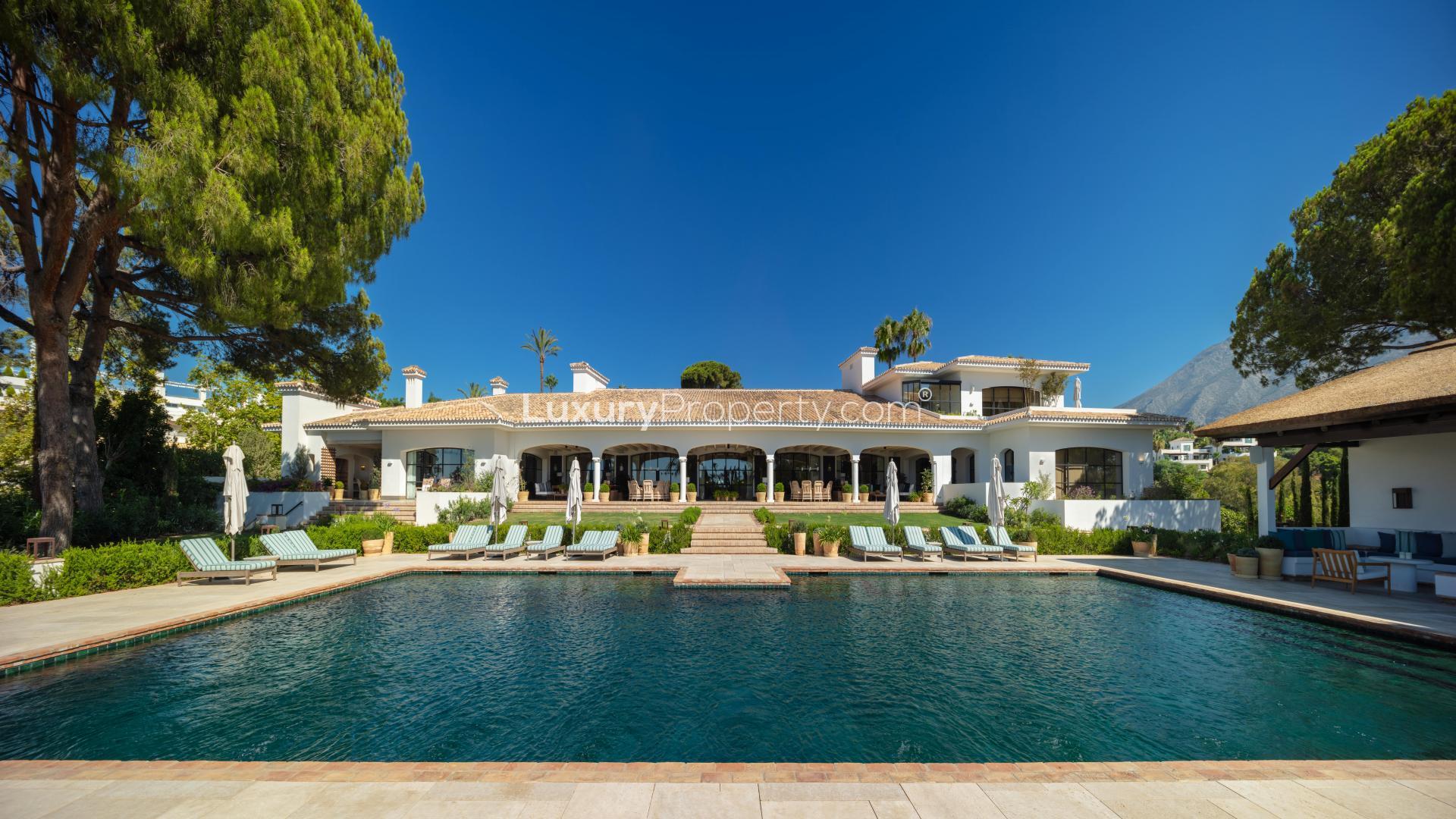 Aerial view of luxurious Marbella villa with pool on Golden Mile, surrounded by greenery