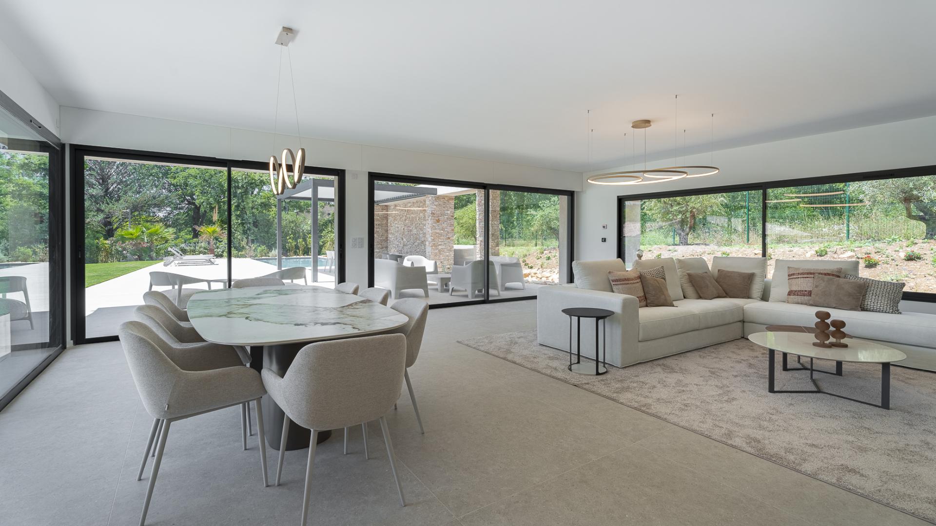 Outdoor patio with modern seating, dining area, and lush garden view in luxury villa