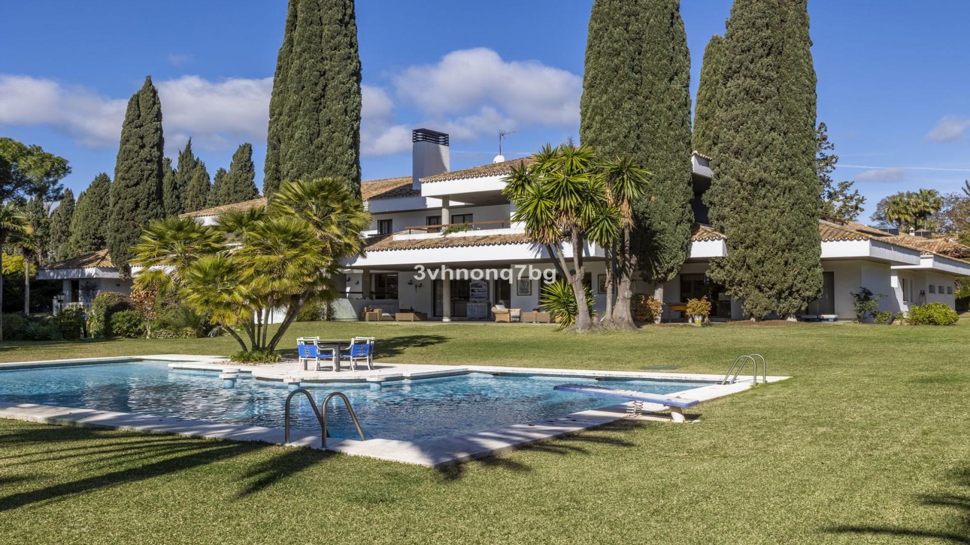 Covered terrace with wicker seating overlooking pool in Guadalmina Baja, Marbella villa