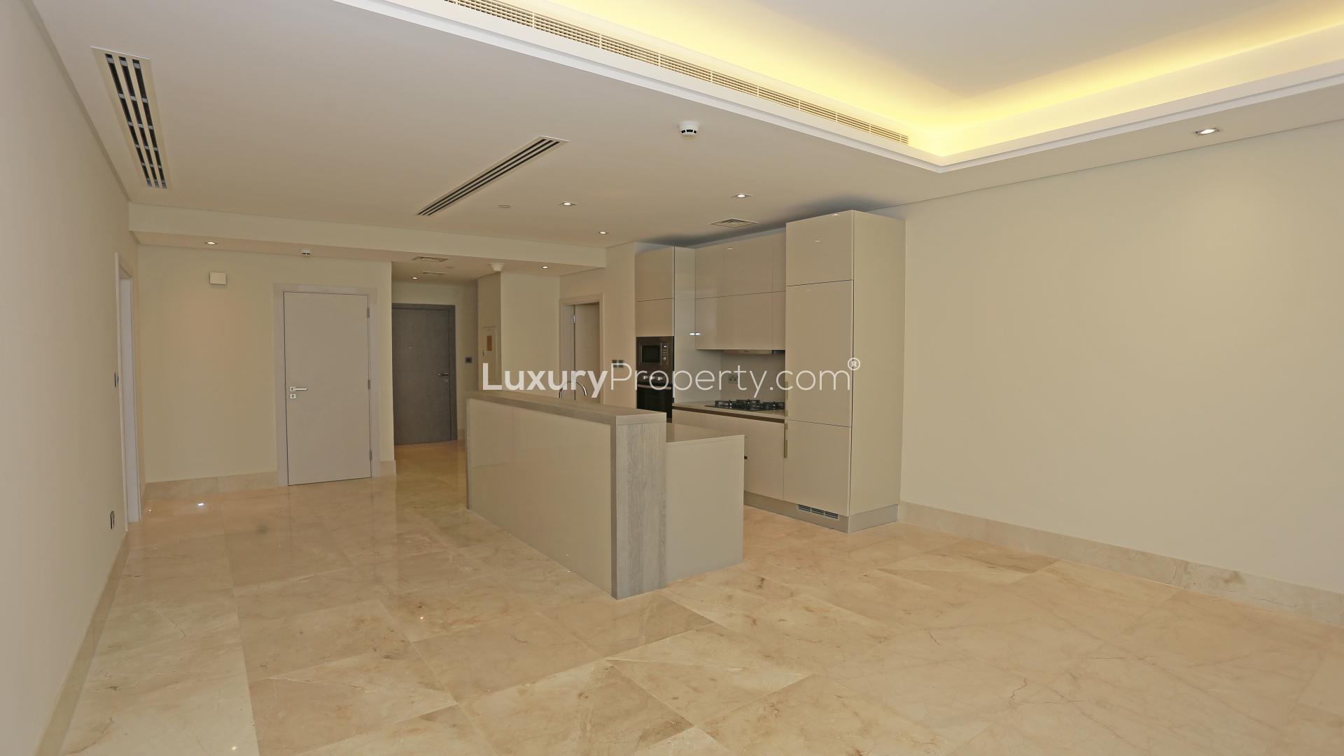 "Stunning sea view from two-bed apartment balcony in Palm Jumeirah, The Crescent.",Modern kitchen in two-bedroom Palm Jumeirah apartment for sale, featuring sleek cabinetry and lighting
