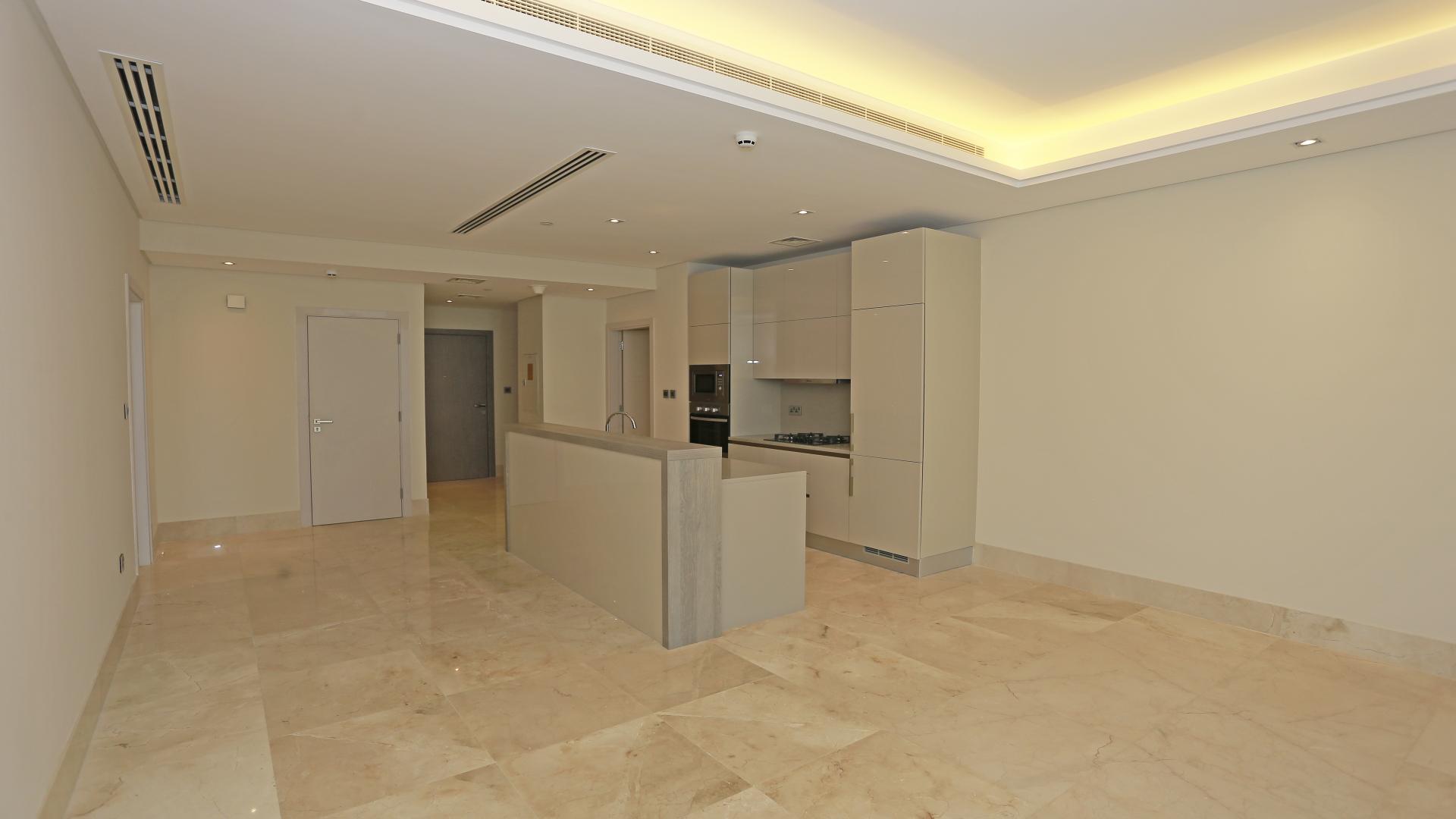 "Stunning sea view from two-bed apartment balcony in Palm Jumeirah, The Crescent.",Modern kitchen in two-bedroom Palm Jumeirah apartment for sale, featuring sleek cabinetry and lighting