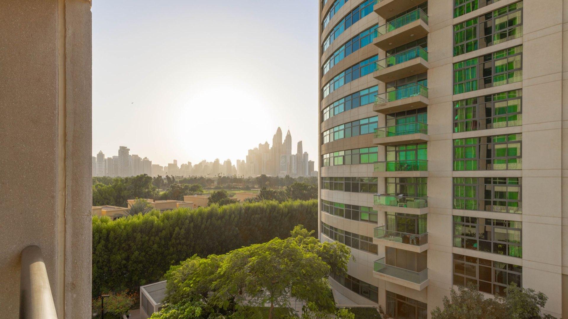 "Balcony view from 2-bedroom apartment in Fairways West, The Views, Dubai, for sale.","View from 2-bedroom apartment in Fairways West, The Views, overlooking city skyline at sunset.",Spacious living room in 2-bedroom apartment, Fairways West, The Views, with modern decor