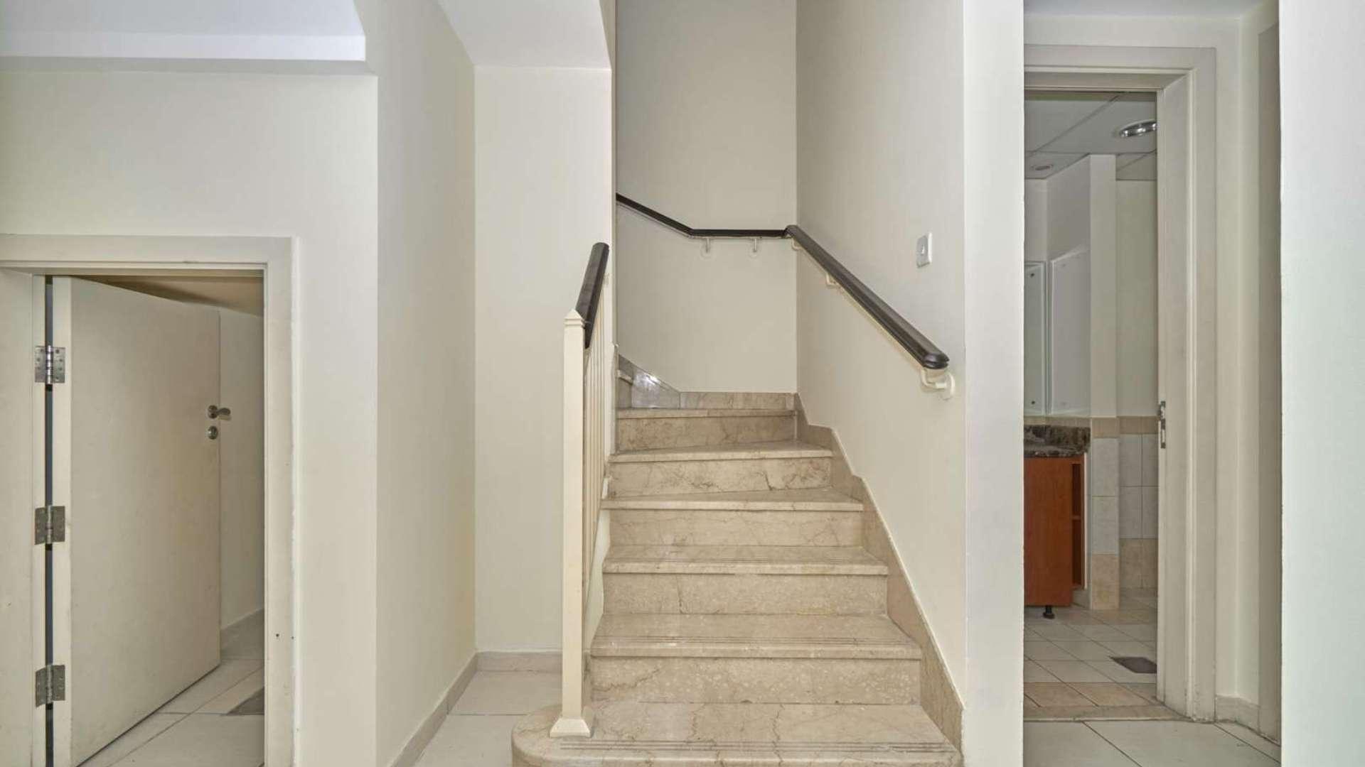 Modern kitchen in 2-bedroom villa, Springs 7, featuring sleek cabinetry and tiled backsplash