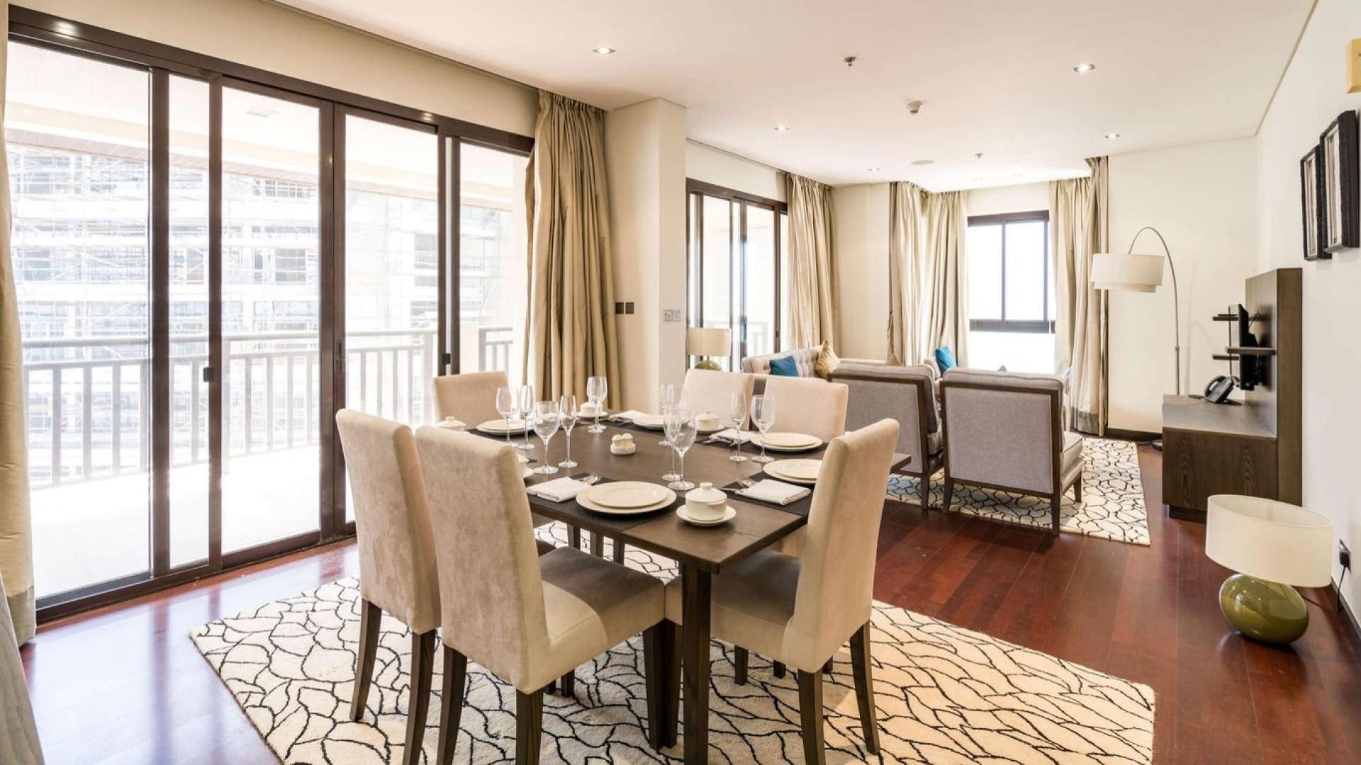 Modern living room in Palm Jumeirah apartment with elegant decor and dining area