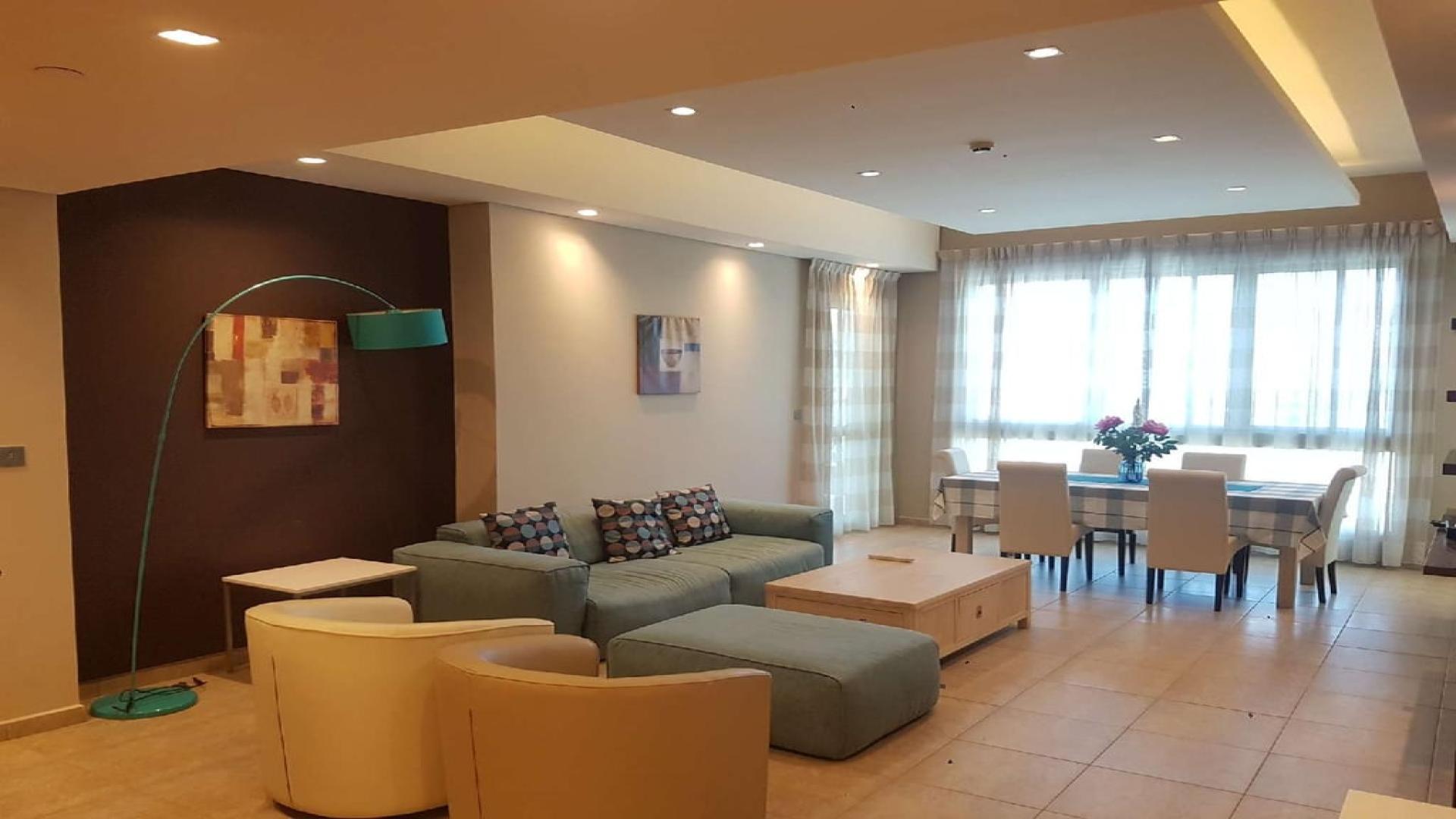 Modern living room in Palm Jumeirah apartment, featuring cozy seating and dining area