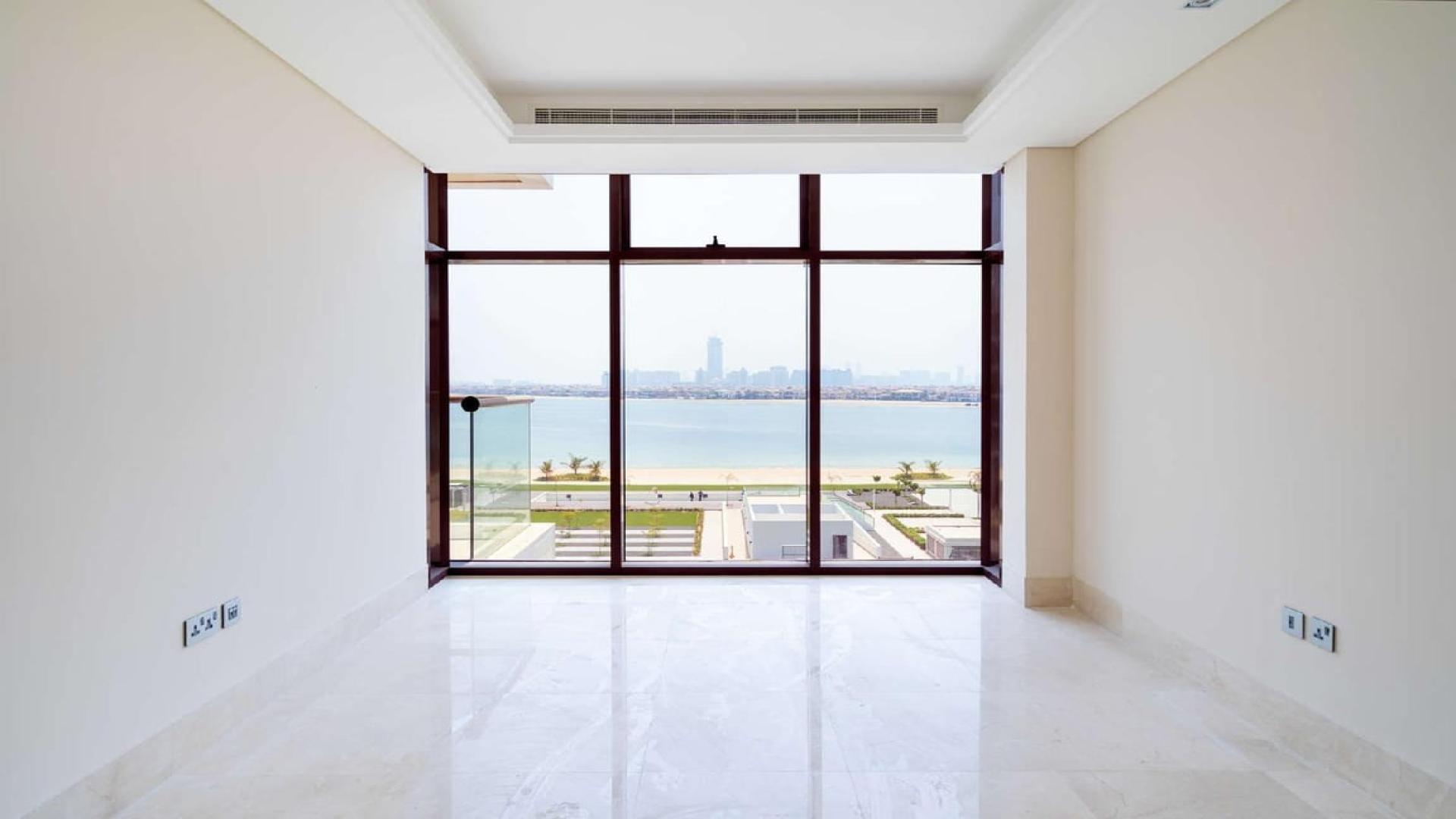 Empty living room with sea view from large windows in Palm Jumeirah apartment
