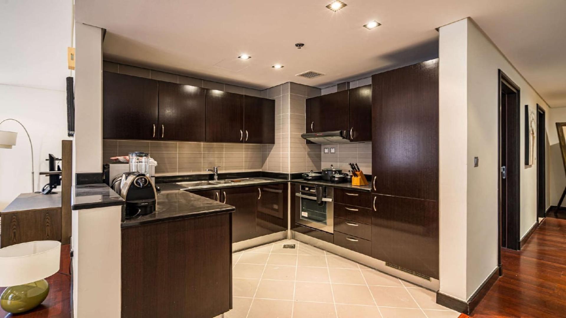 Modern kitchen with dark wood cabinets in Palm Jumeirah two-bedroom apartment for rent