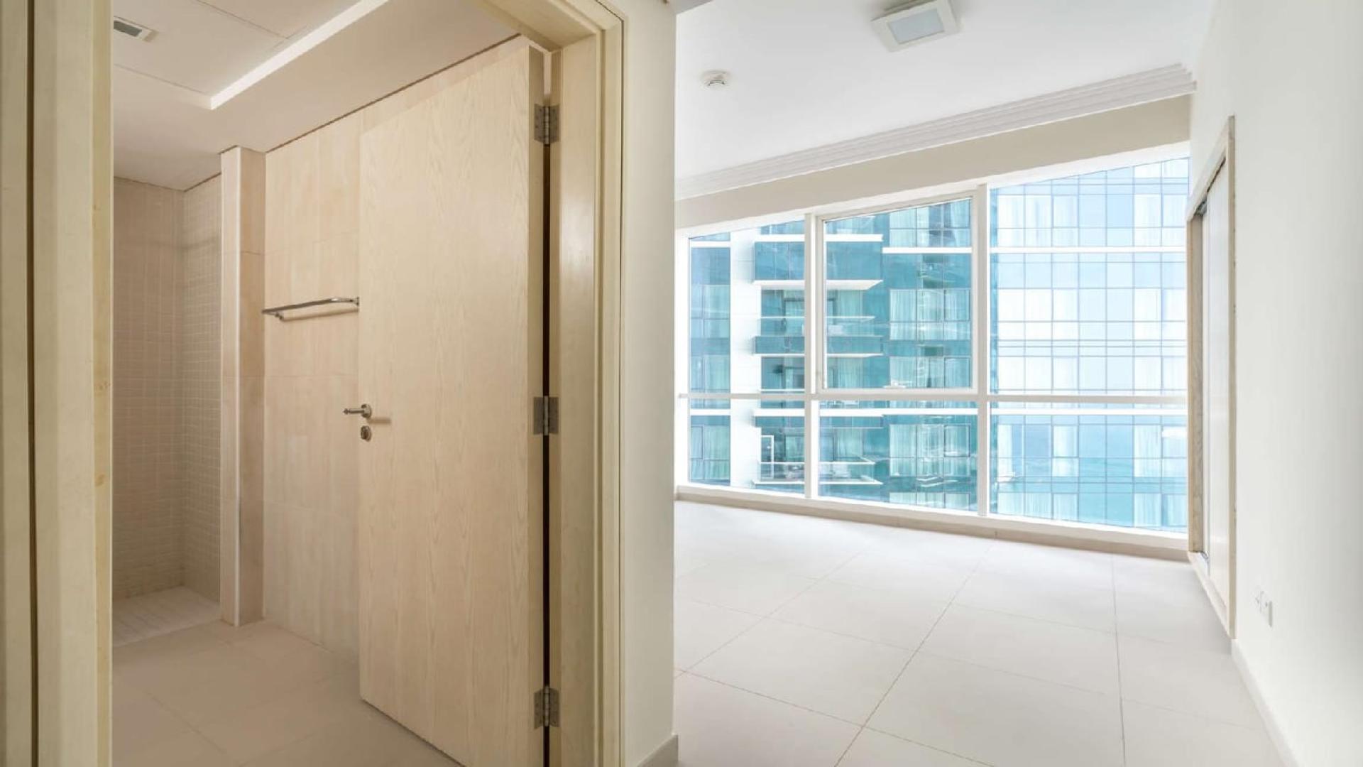 Empty living room with large windows in Jumeirah Beach Residence apartment for rent