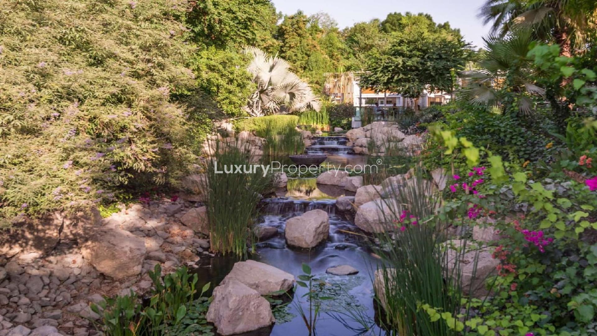 Spacious living room in 2-bedroom apartment, Ashjar Al Barari, with modern decor and greenery view