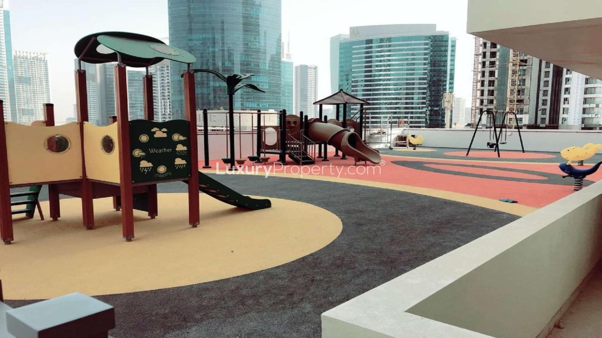 Playground area in Bahwan Tower, Abu Shagara with cityscape views. Family-friendly apartment rental