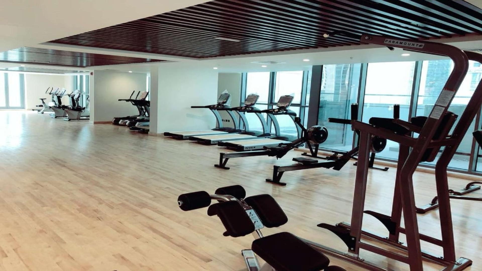 Modern gym in Bahwan Tower, Abu Shagara; spacious, well-equipped fitness area with natural light