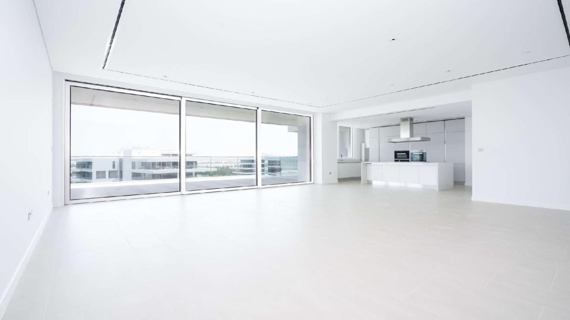 Spacious open-plan living area with modern kitchen in Al Barari's Seventh Heaven apartment