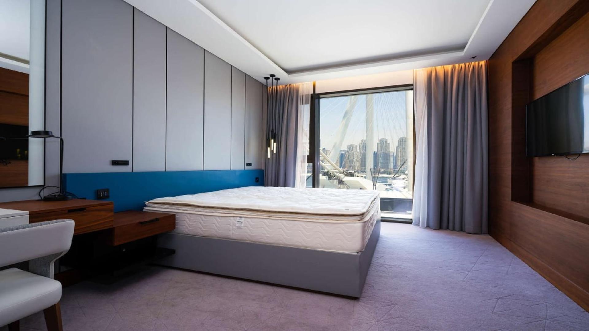 "View from two-bedroom apartment balcony at Caesars Resort, Bluewaters, Dubai skyline visible.",Luxurious bedroom with city view in two-bedroom apartment, Caesars Resort, Bluewaters, Dubai