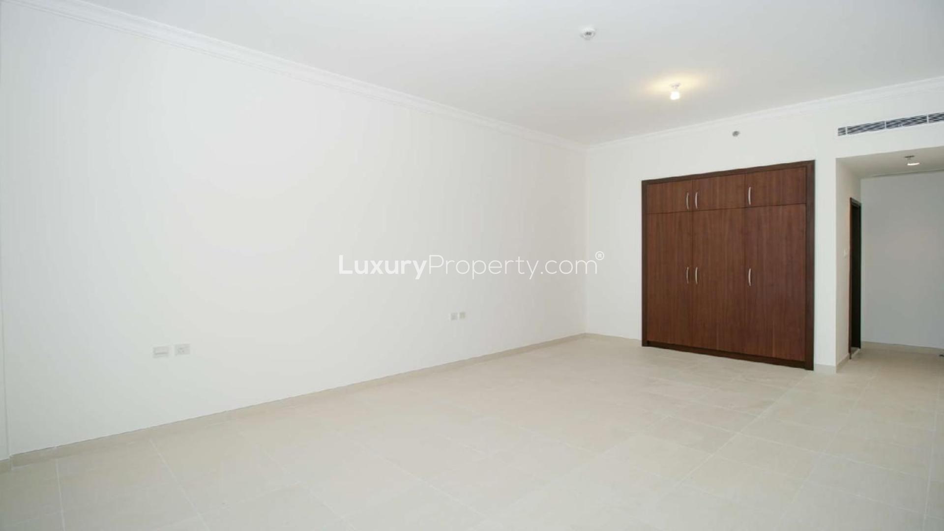 Empty living room with tiled floor and open kitchen in Sarai Apartments, Palm Jumeirah