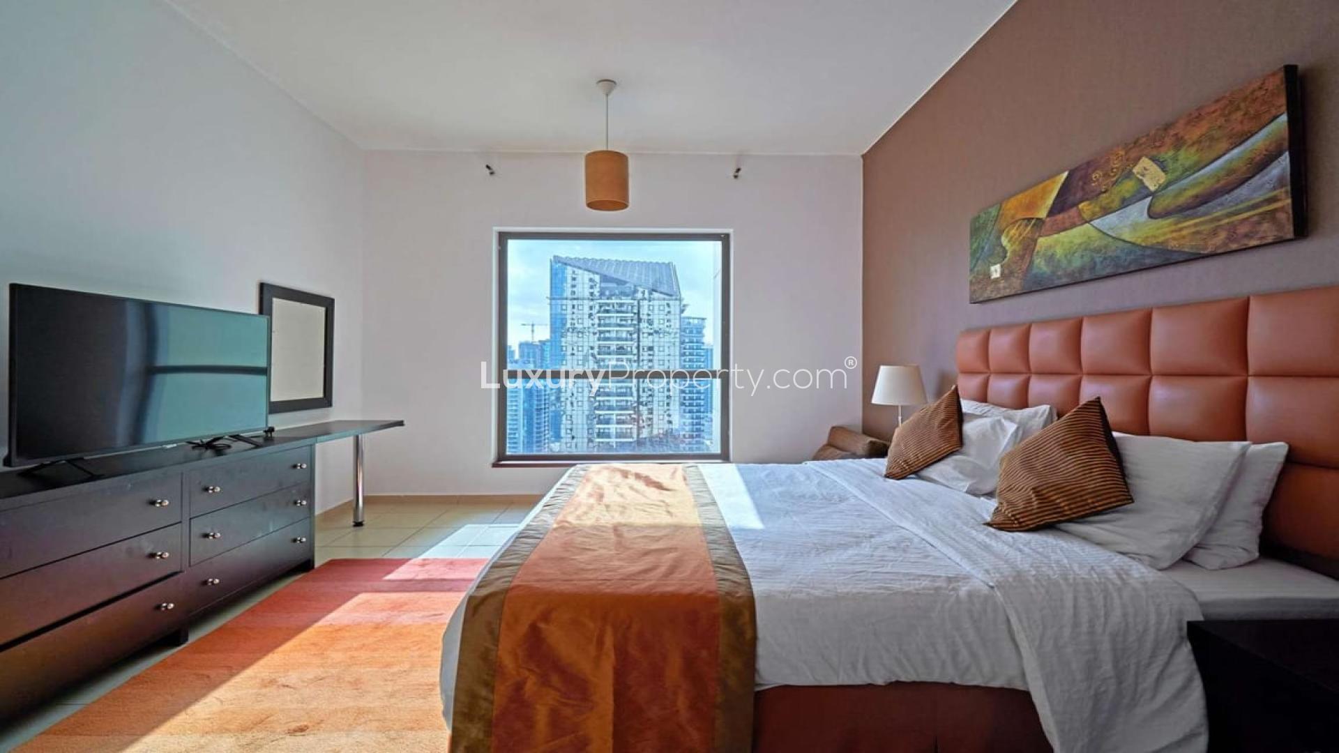 "Stunning high-rise view of JBR waterfront and cityscape from Shams apartment for rent.","Modern bedroom with city view in beachfront apartment, Shams, Jumeirah Beach Residence, Dubai.",Modern living room and dining area in beachfront JBR apartment for rent at Shams