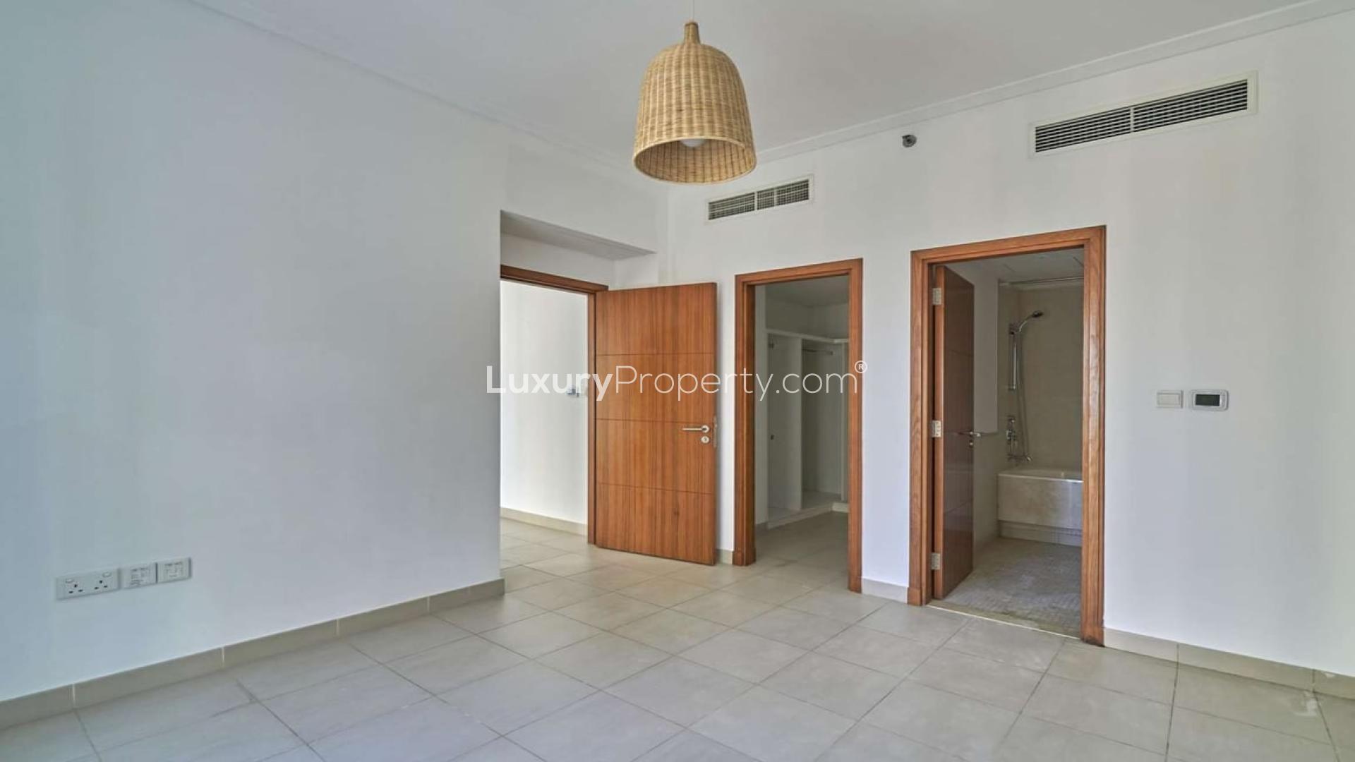 Tall residential buildings in Marina Promenade, Dubai Marina, surrounded by palm trees