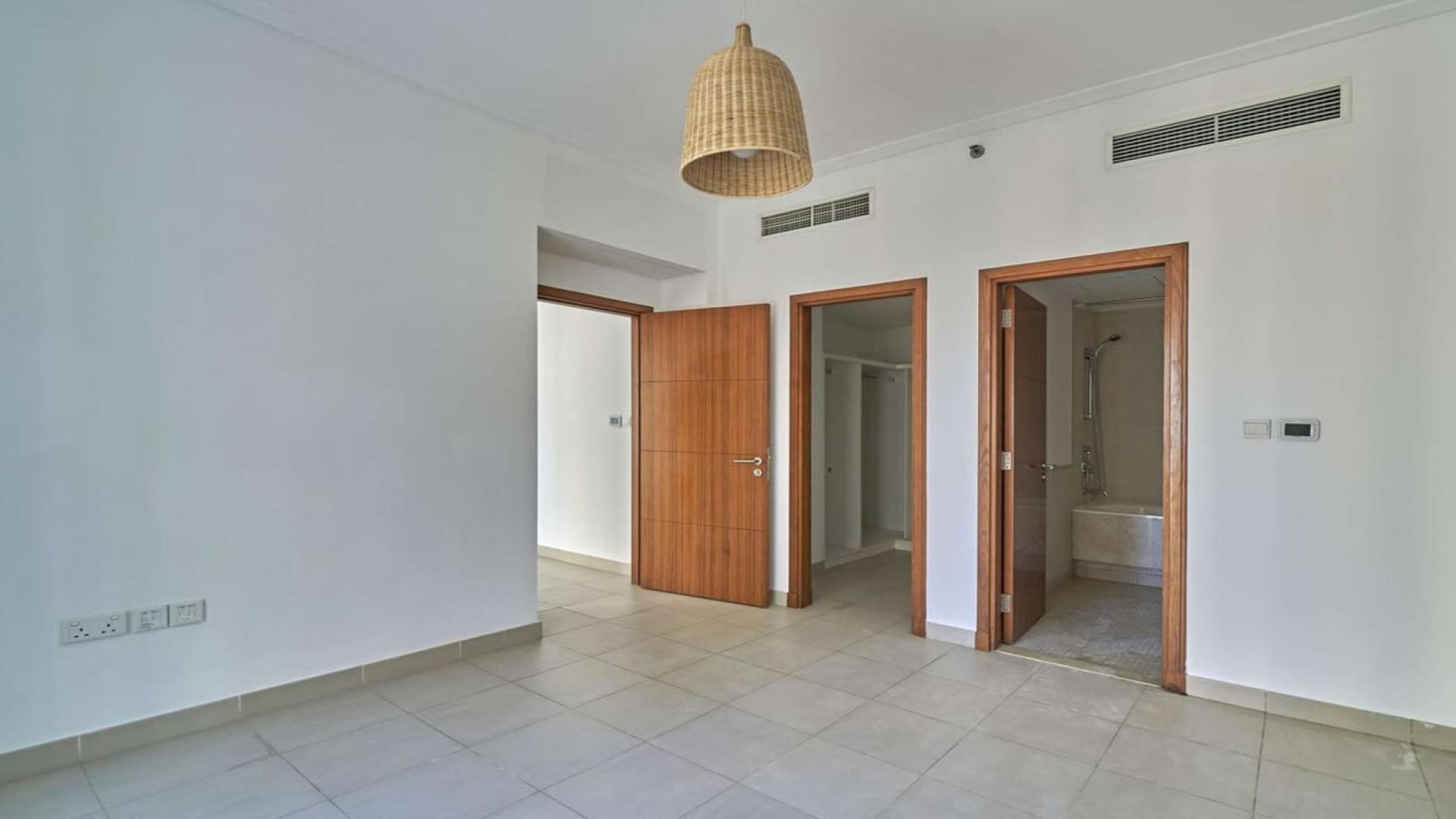 Tall residential buildings in Marina Promenade, Dubai Marina, surrounded by palm trees