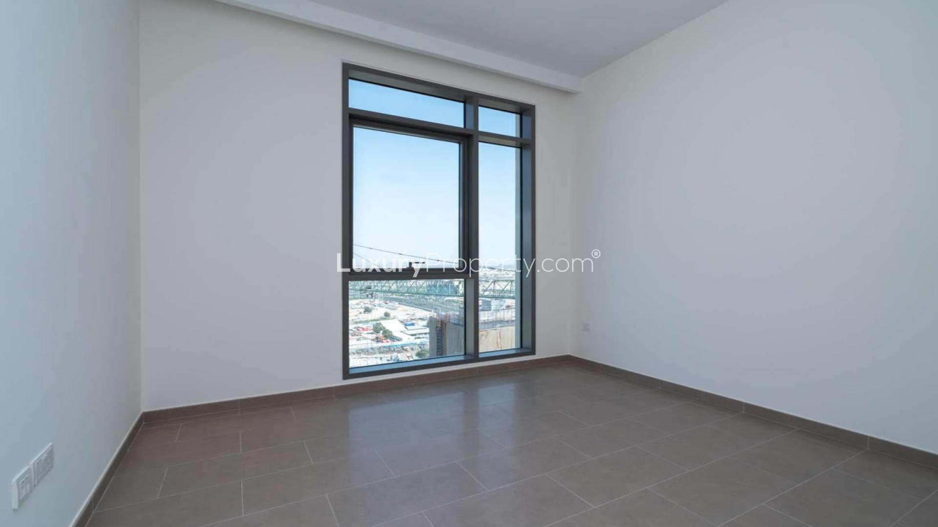 Empty high-floor bedroom with large window and skyline views in Dubai Hills Estate apartment