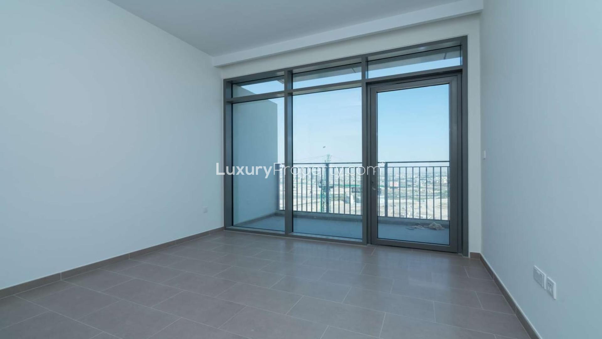 Empty room with large windows and balcony view in Dubai Hills Estate apartment