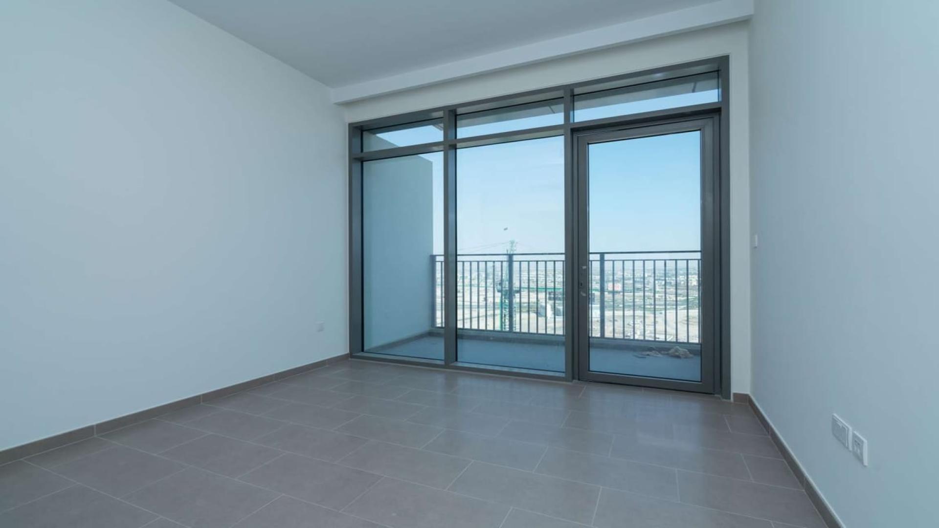 Empty room with large windows and balcony view in Dubai Hills Estate apartment