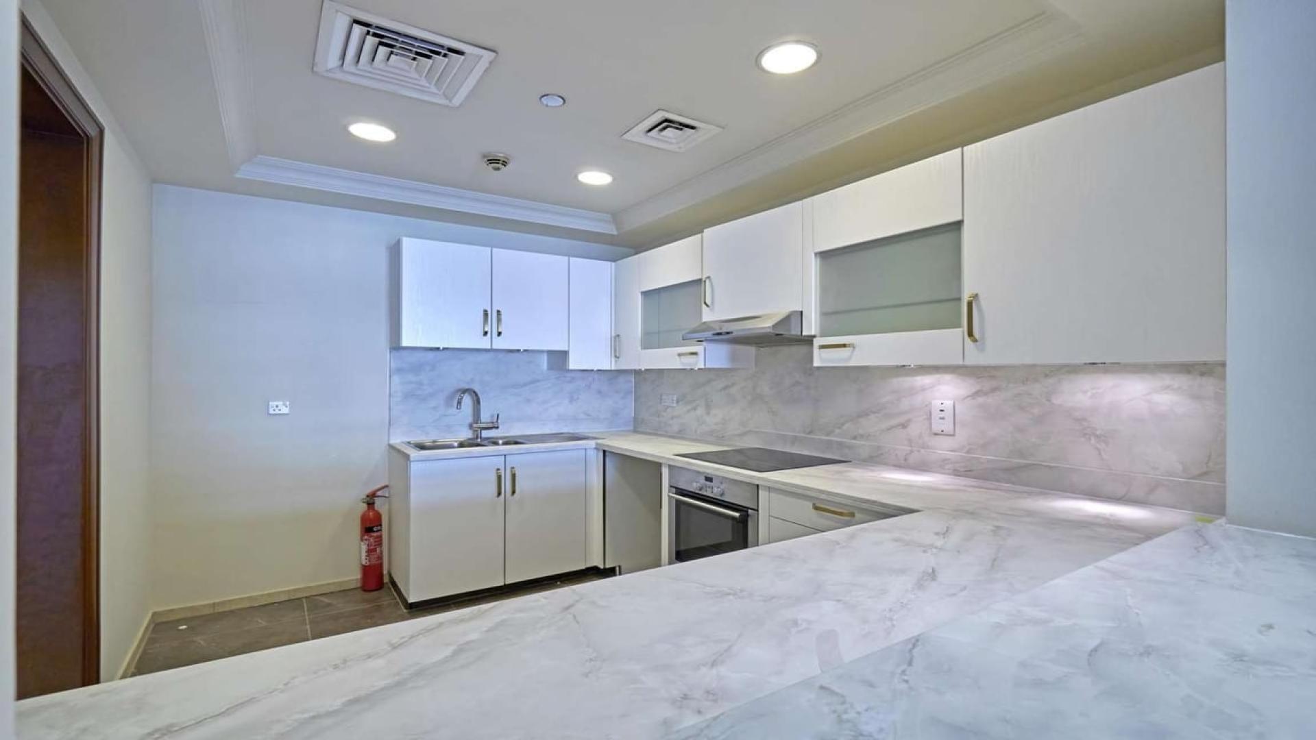 Modern kitchen in 2-bedroom apartment, Shoreline, Palm Jumeirah, with sleek white cabinets