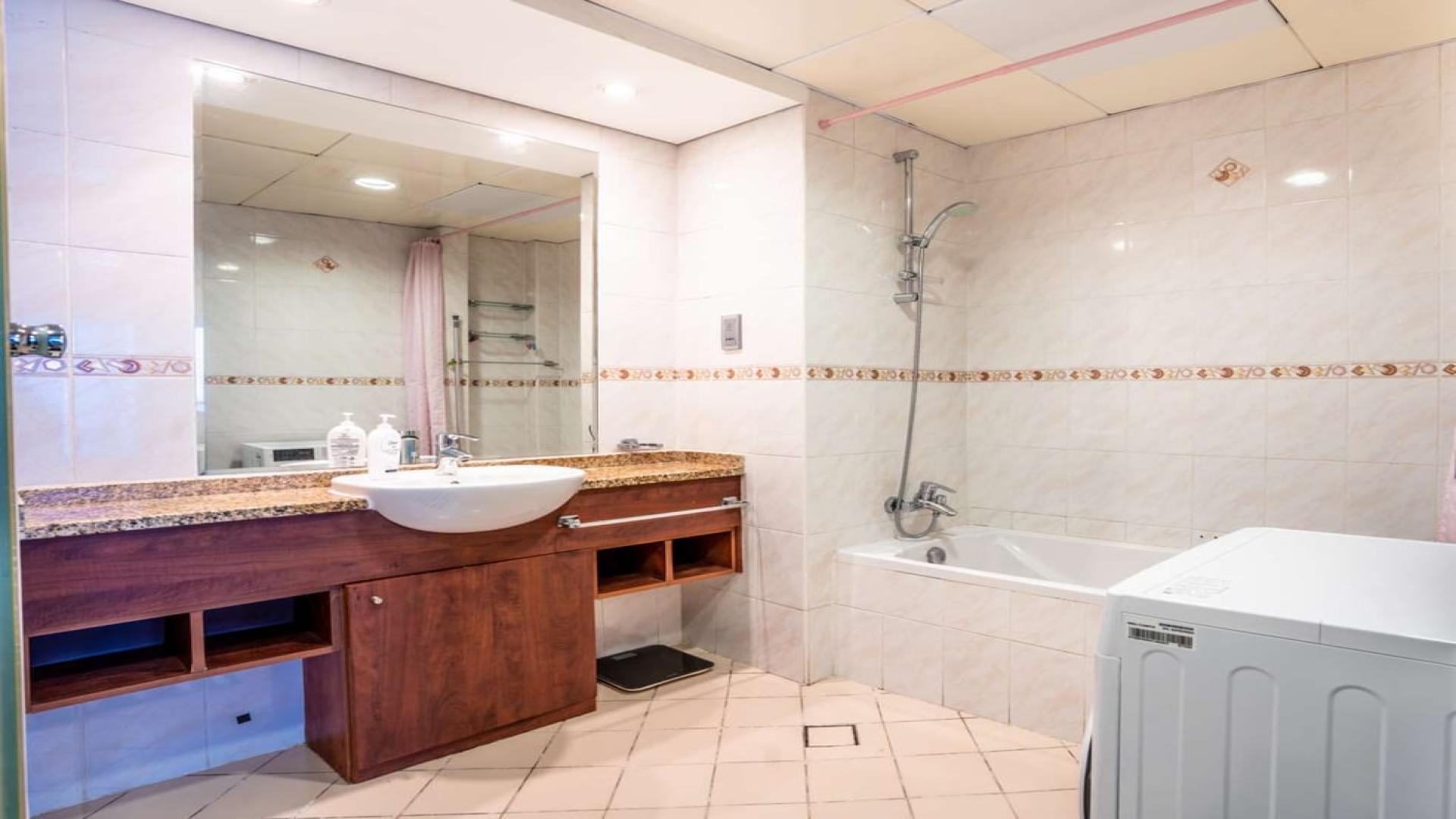 Spacious living room in JLT Lake View apartment with modern decor and balcony access