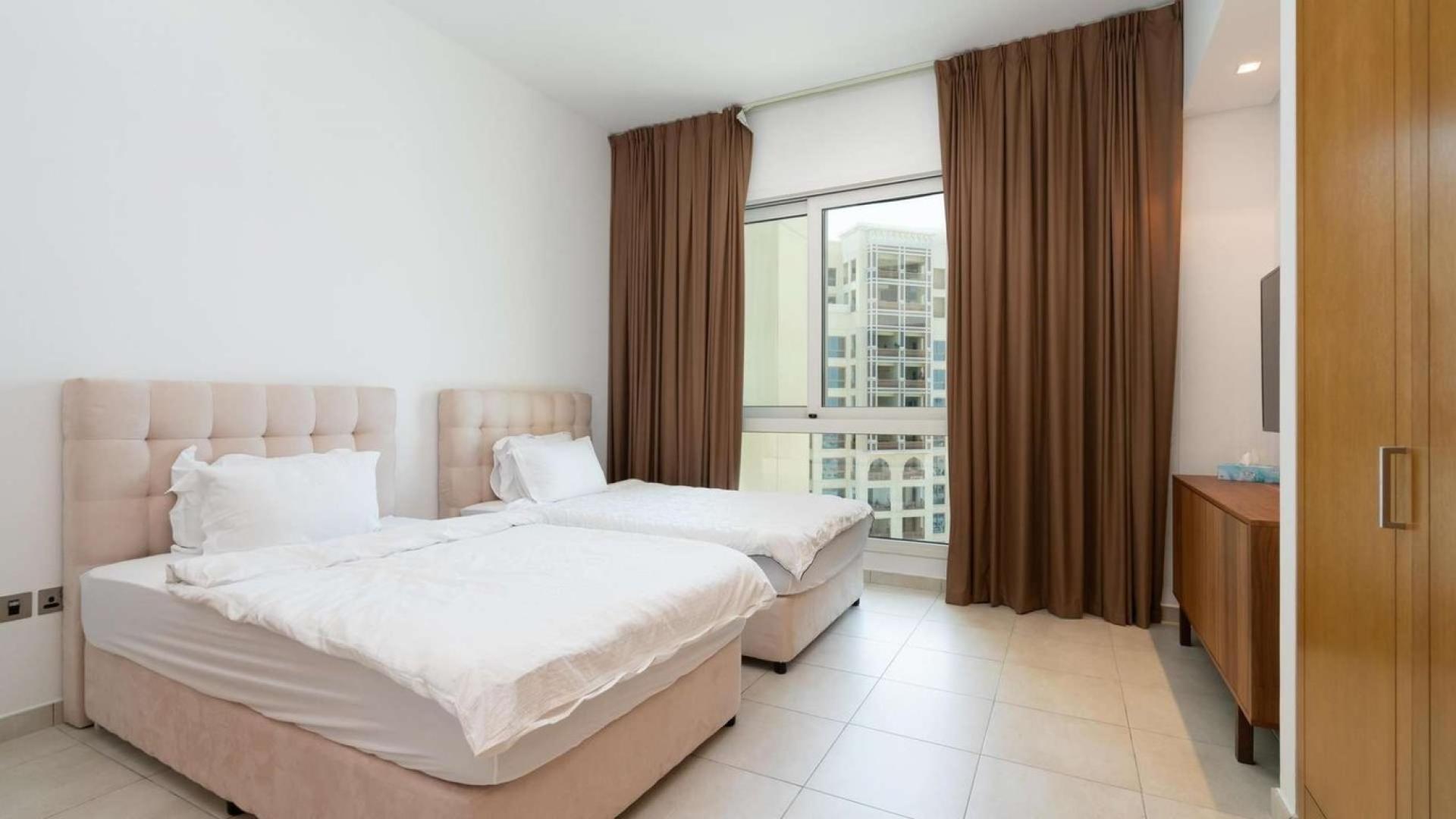 Furnished bedroom in Palm Jumeirah apartment, Marina Residences, with twin beds and window view