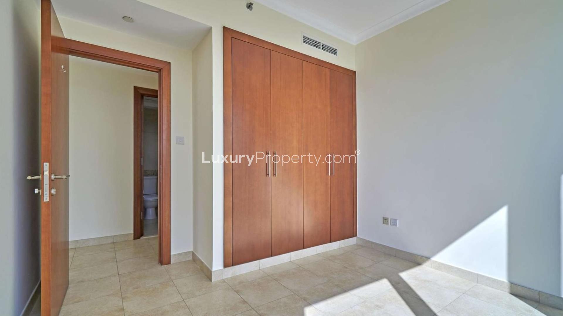 Empty bedroom with built-in wooden wardrobe in The Fairways apartment, The Views