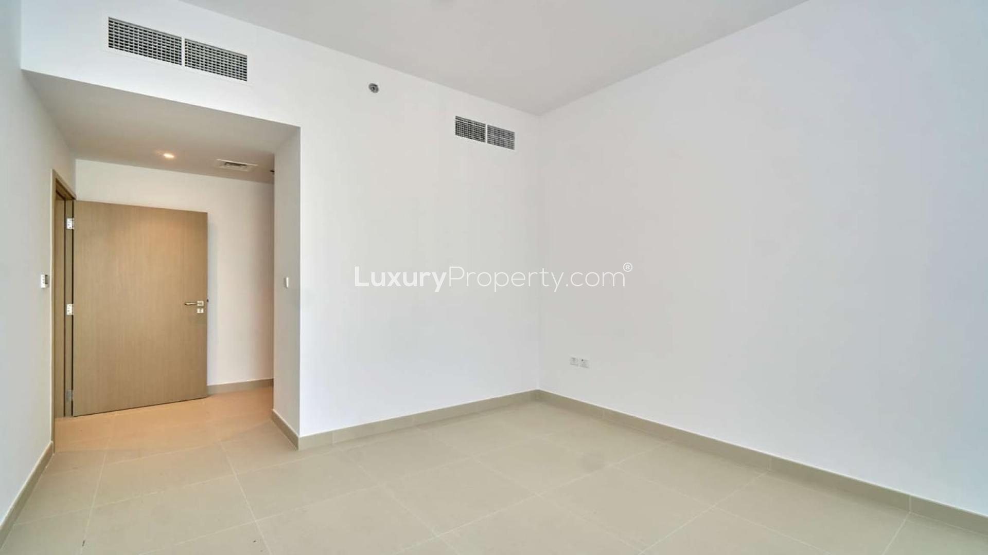 Empty room in 4-bedroom Creek Horizon apartment, Dubai Creek Harbour, with tiled floor and door