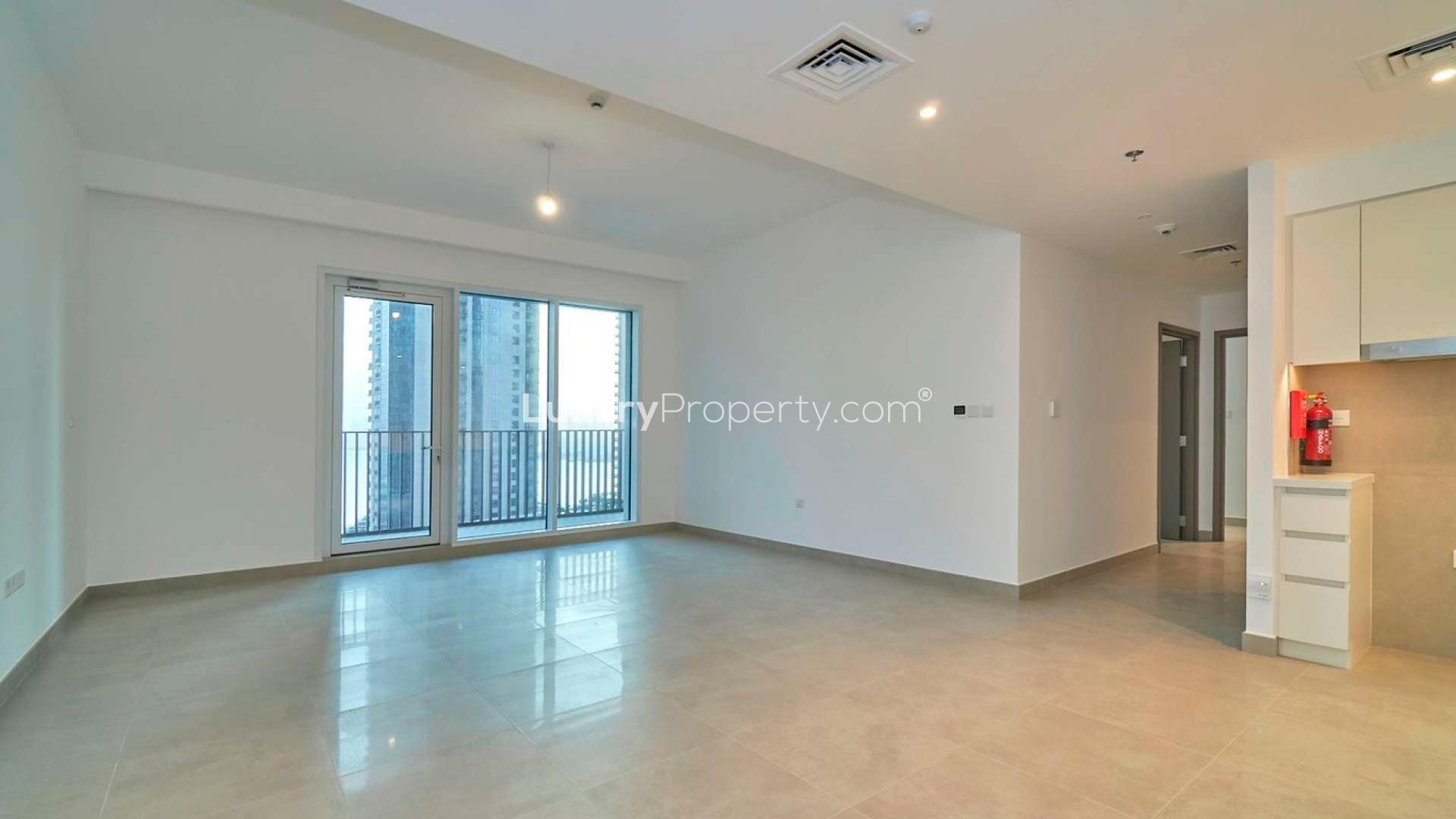Dubai Creek Harbour apartment view with pool, high-rise buildings, and waterfront at sunset