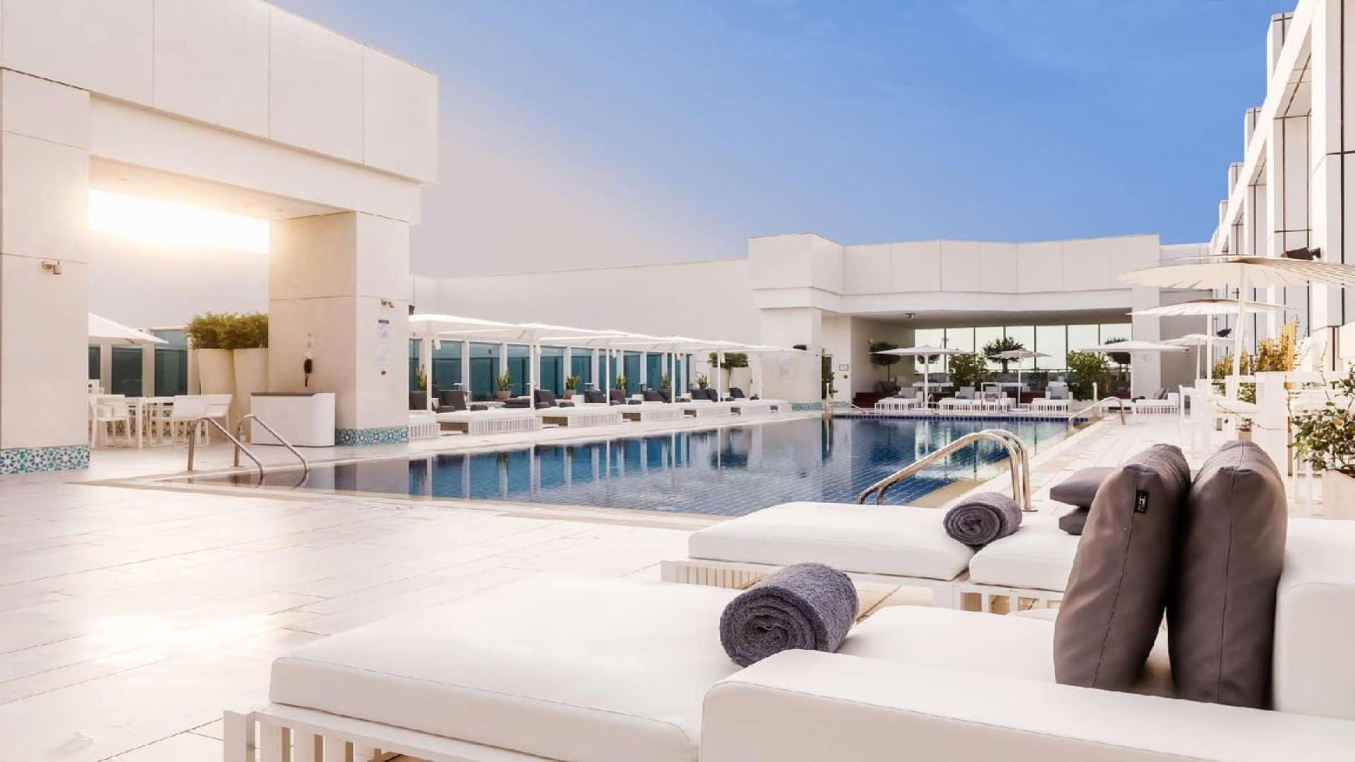 Outdoor pool lounge at Sheraton Grand Hotel, Sheikh Zayed Road, luxury apartment amenities