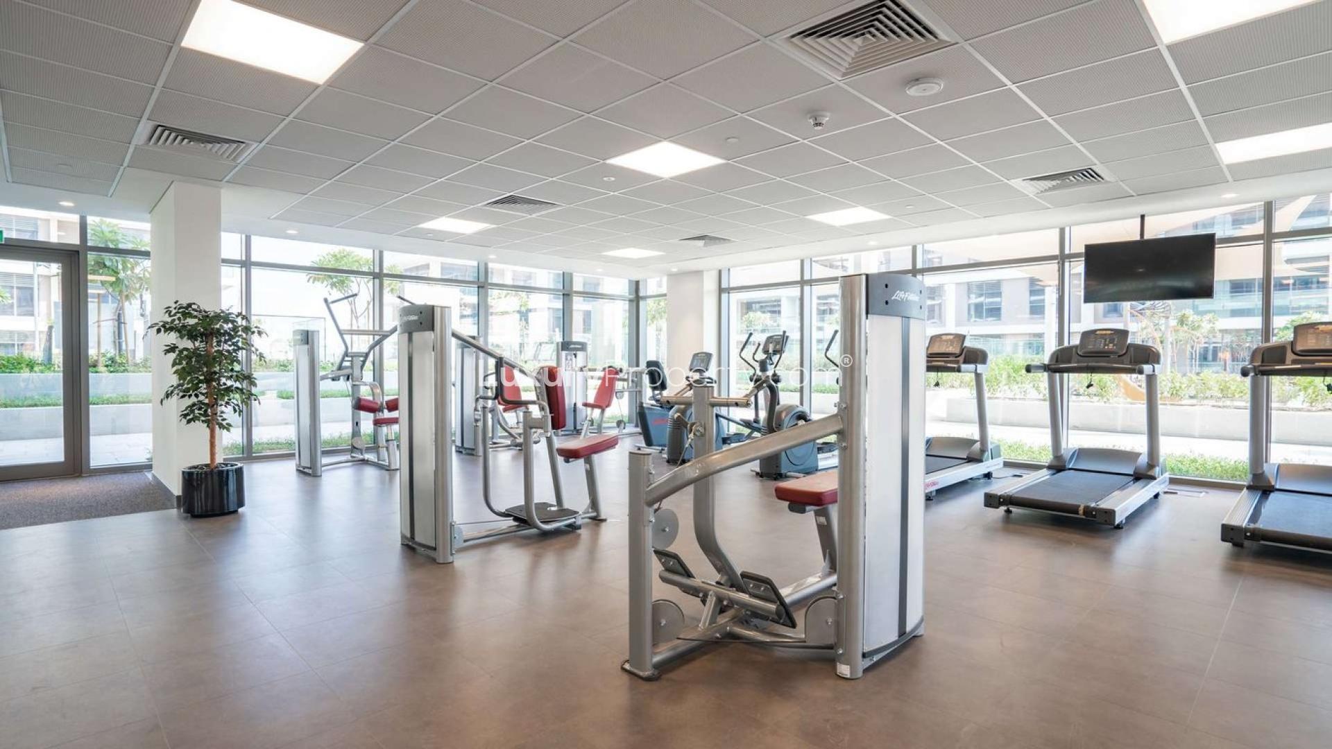 Balcony view of lush park in Acacia Park Heights, Emaar South, Dubai apartment for rent