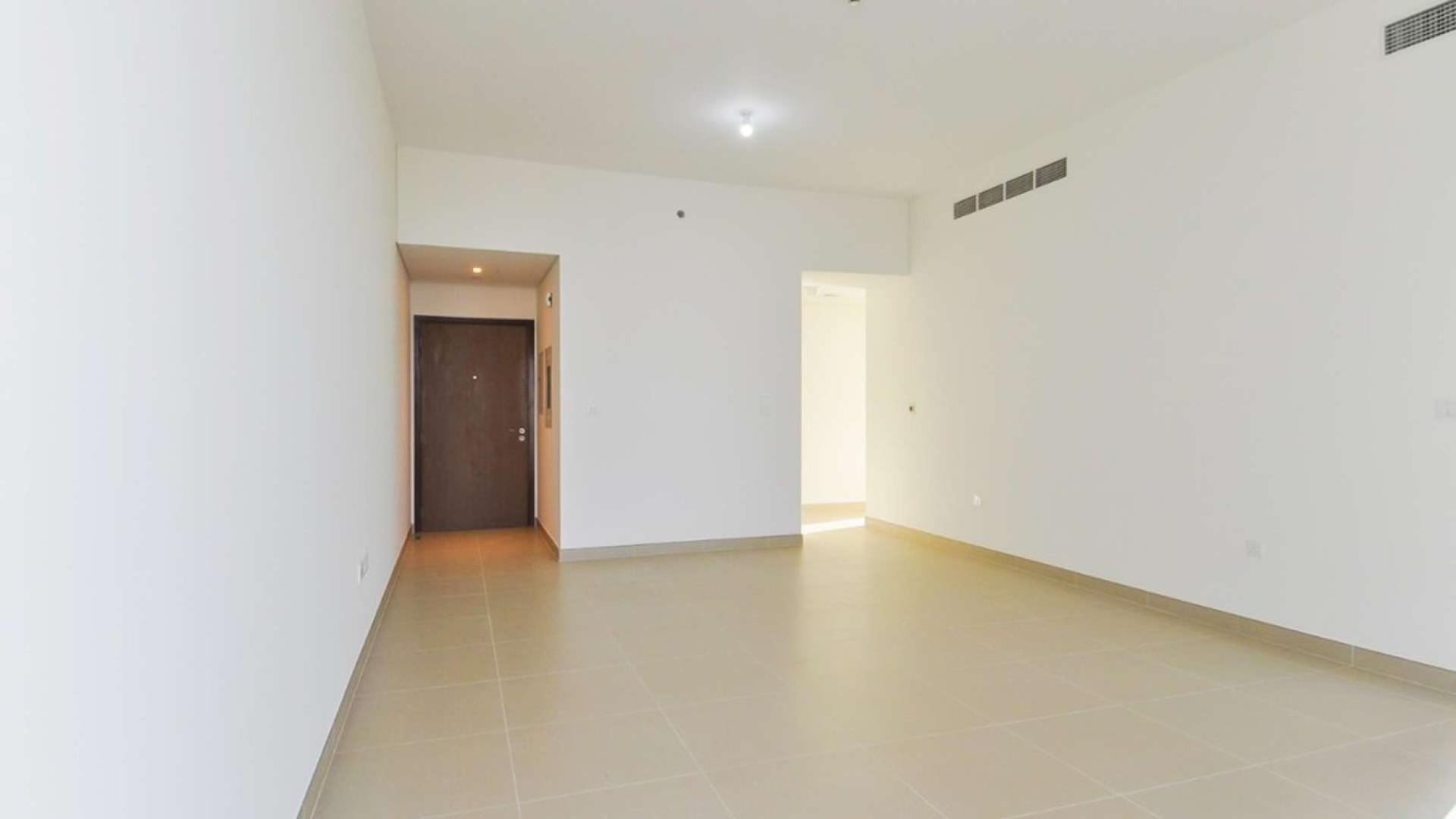 Modern living room in two-bedroom Dubai Marina apartment, featuring tiled floors and neutral walls