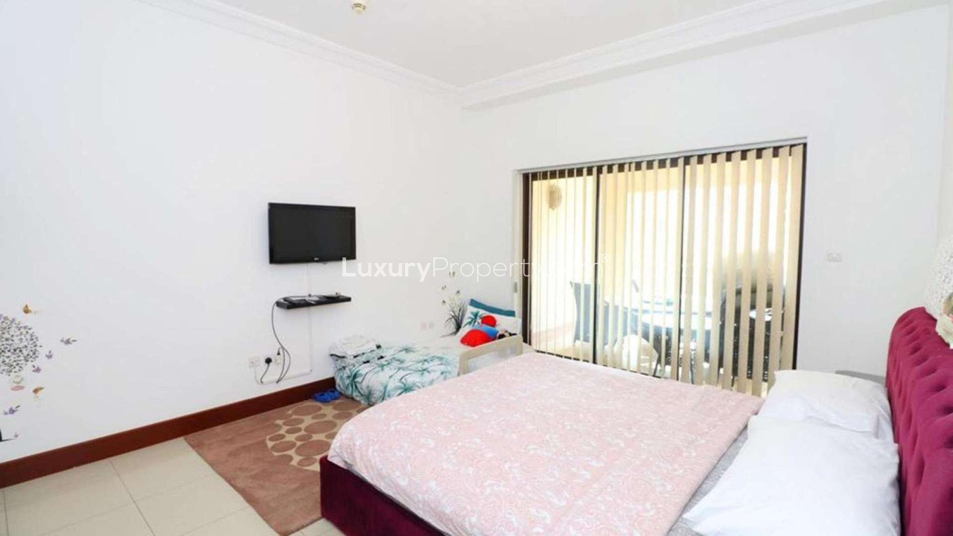 "View from 2-bedroom apartment balcony in Palm Jumeirah’s Golden Mile, Dubai skyline visible.",Bedroom in 2-bedroom apartment, Palm Jumeirah’s Golden Mile, with balcony view and wall TV