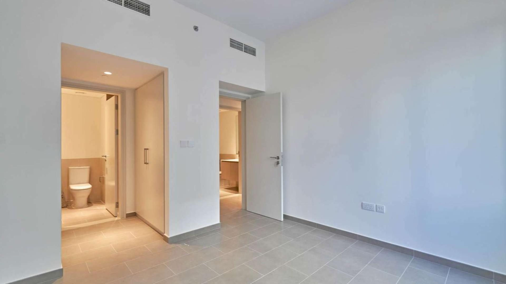 Empty room with large windows and balcony, offering a pool view in Dubai Hills Estate