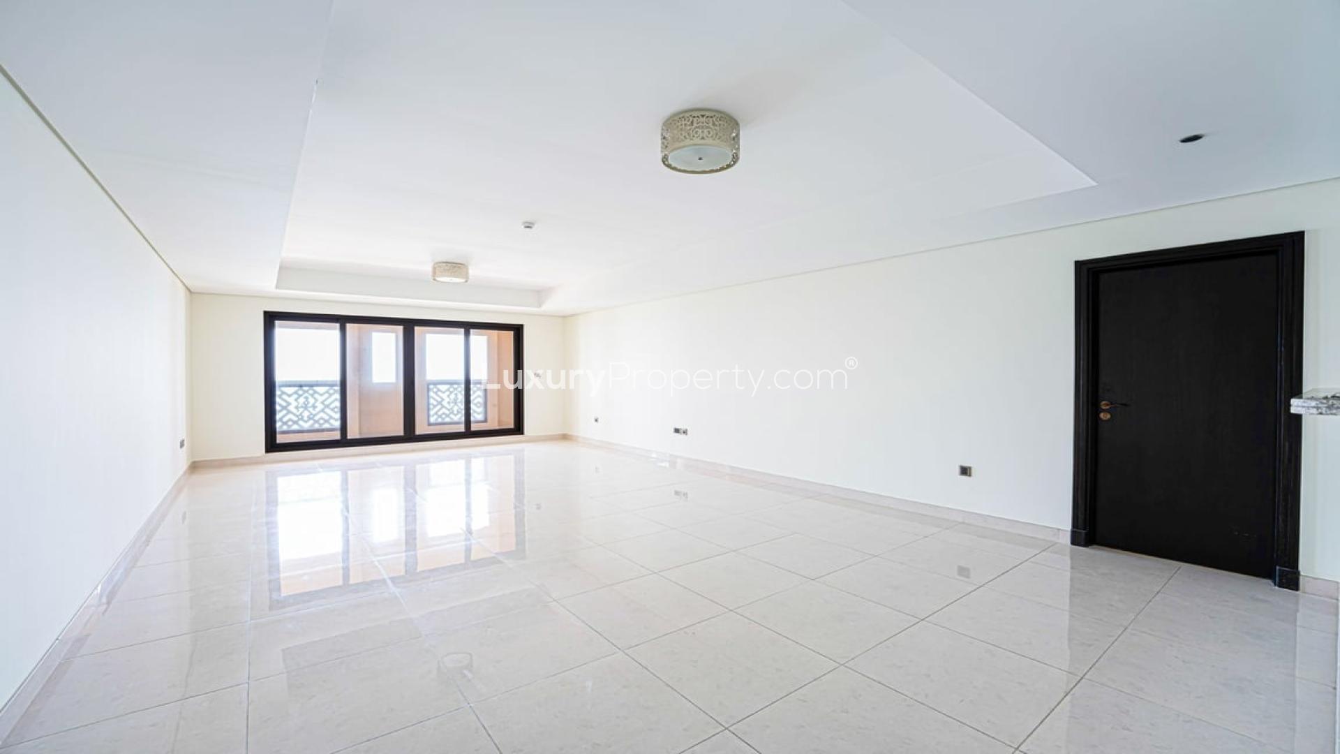 "Palm Jumeirah apartment sea view, beach access, Kingdom of Sheba community, for rent.",Empty living room with tiled floor and large windows in Palm Jumeirah apartment