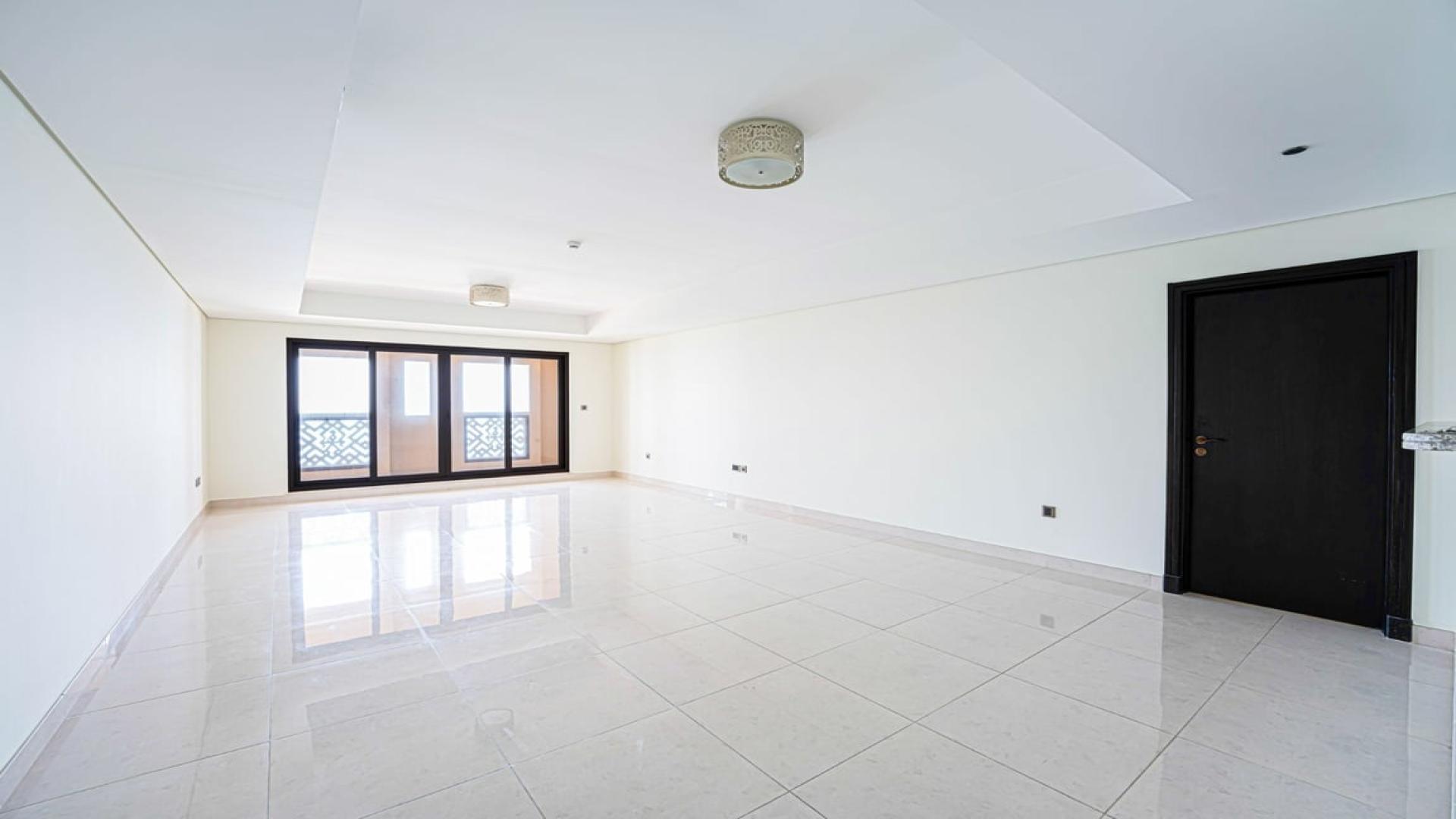 "Palm Jumeirah apartment sea view, beach access, Kingdom of Sheba community, for rent.",Empty living room with tiled floor and large windows in Palm Jumeirah apartment